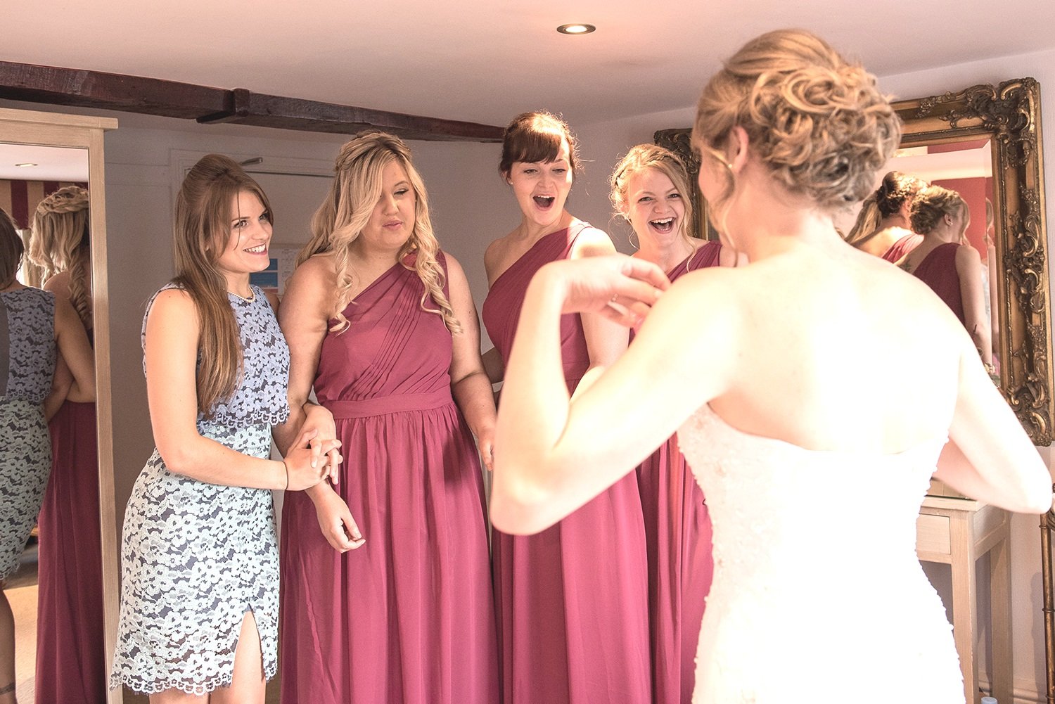 Bridesmaids seeing the bride in her dress for the first time