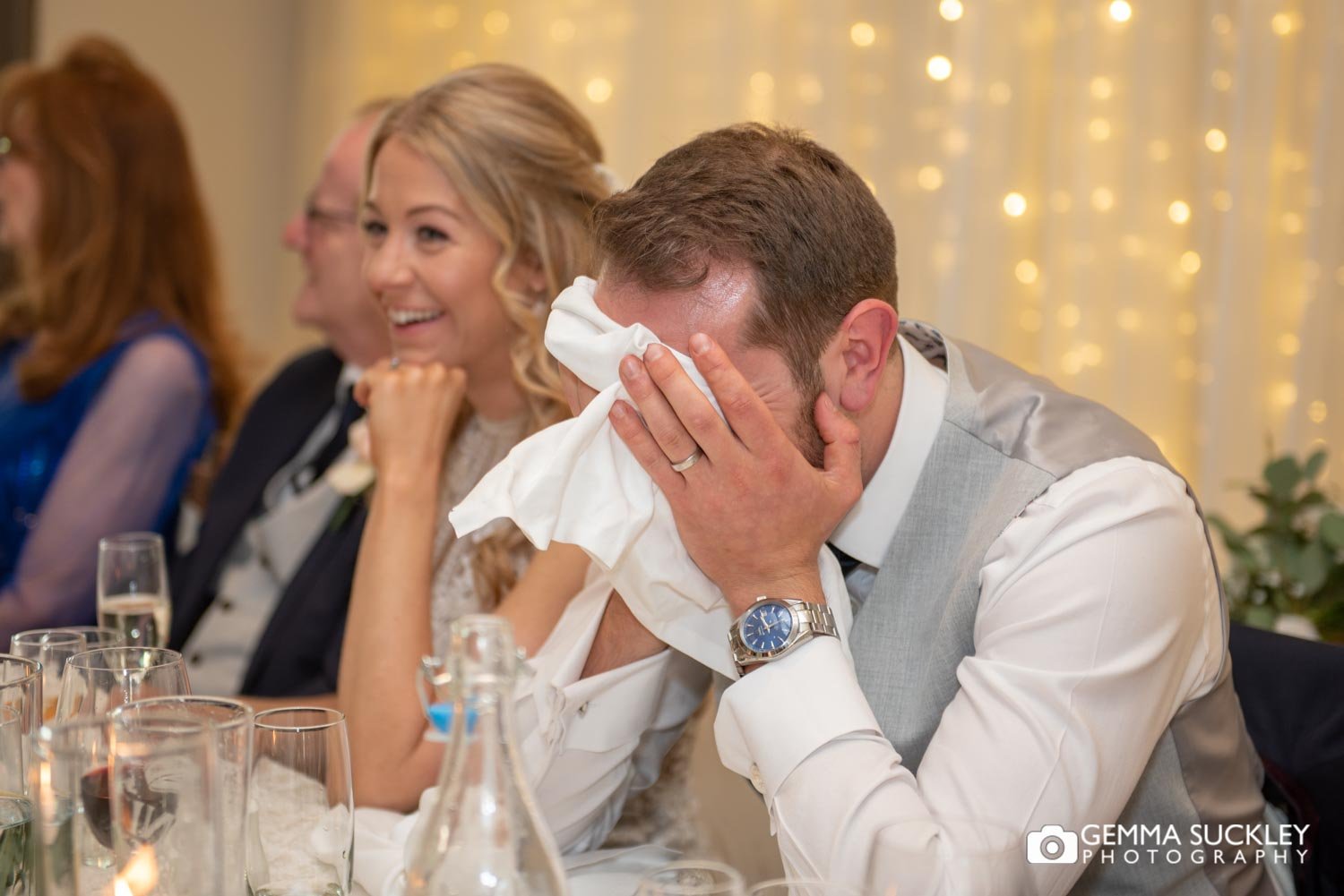 groom sitting with his head in his hands during bestman speeches