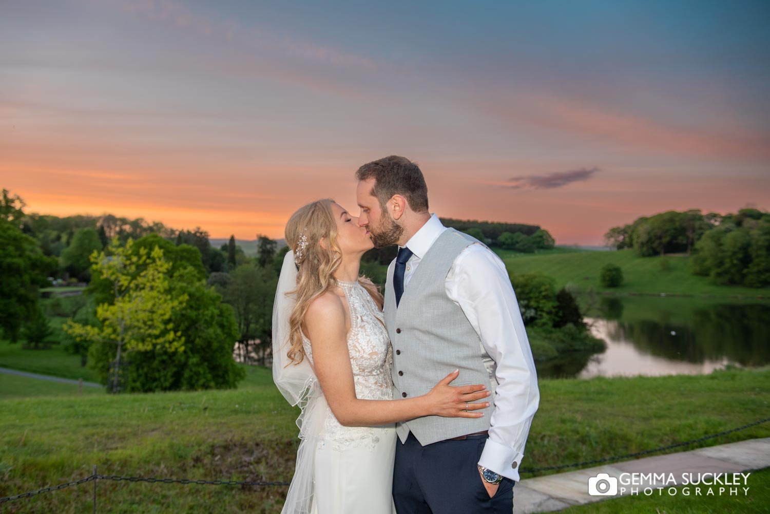 bride and groom kissing as the sunsets on coniston lake in skipton
