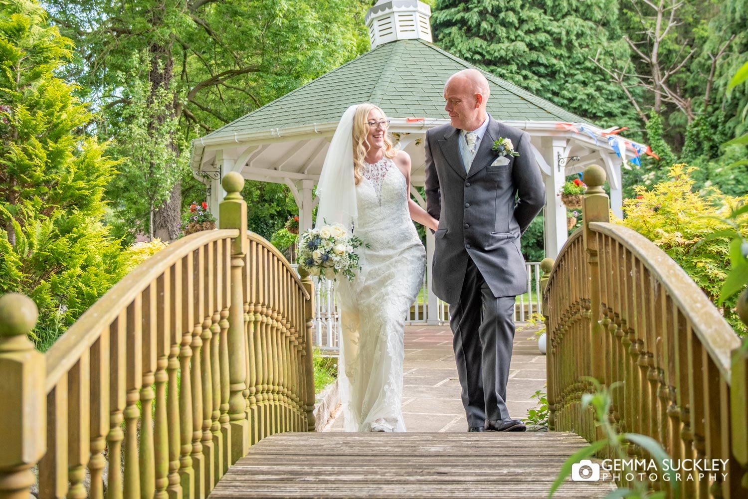 bride and groom walking over a bride at steeton hall