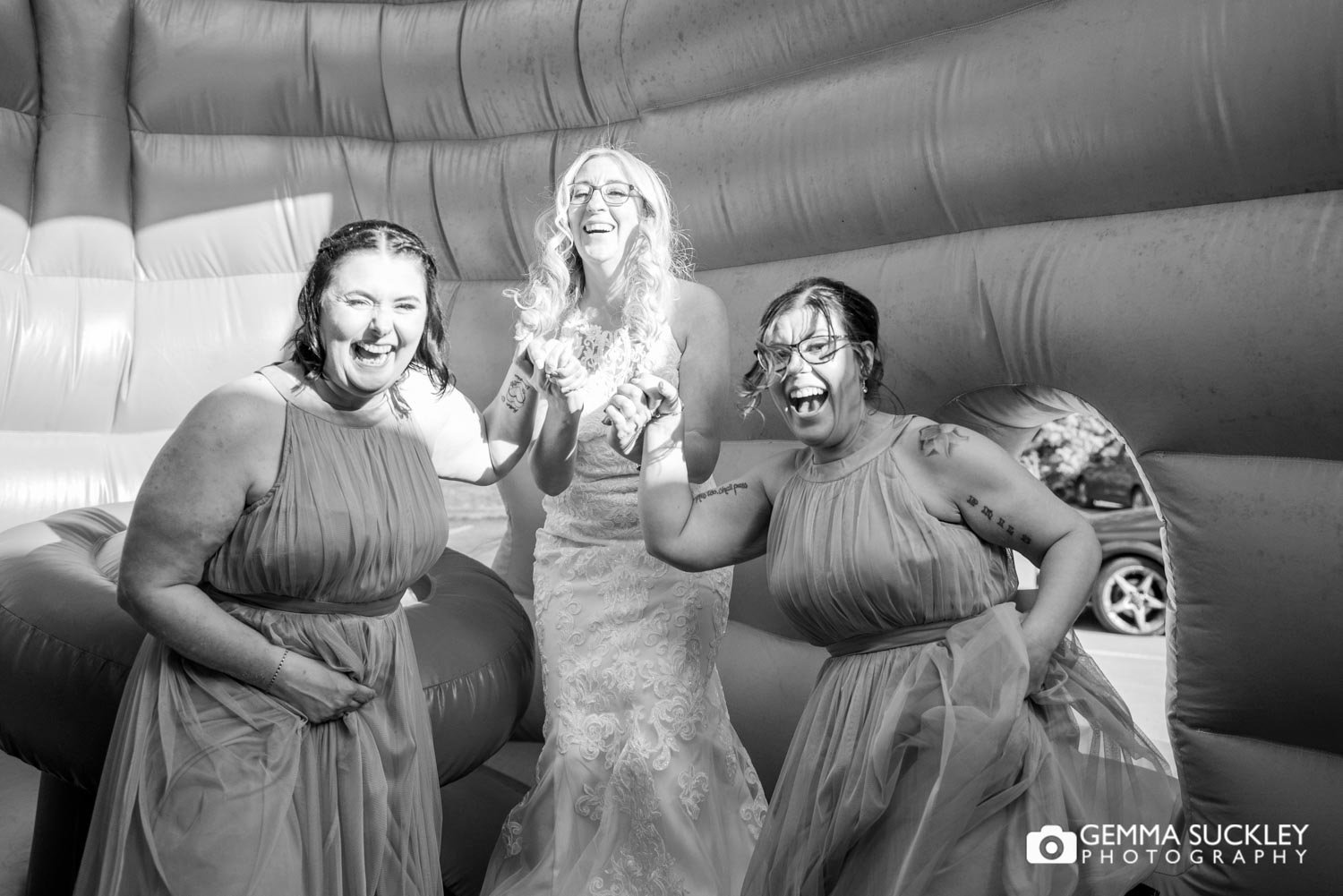 bride and ger bridesmaids jumping on a bouncing castle