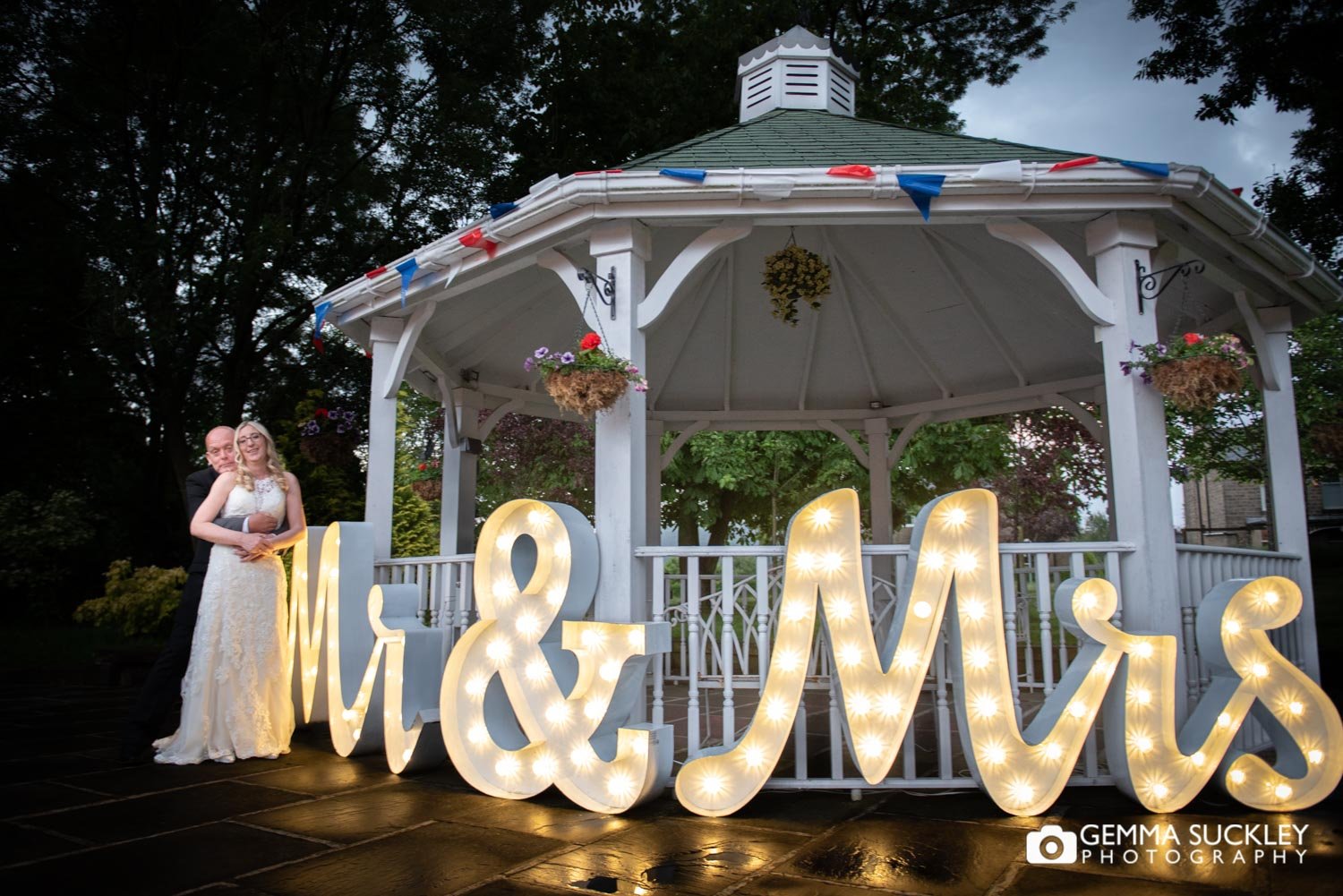 bride and groom smiling next to Mr and Mrs light up letters