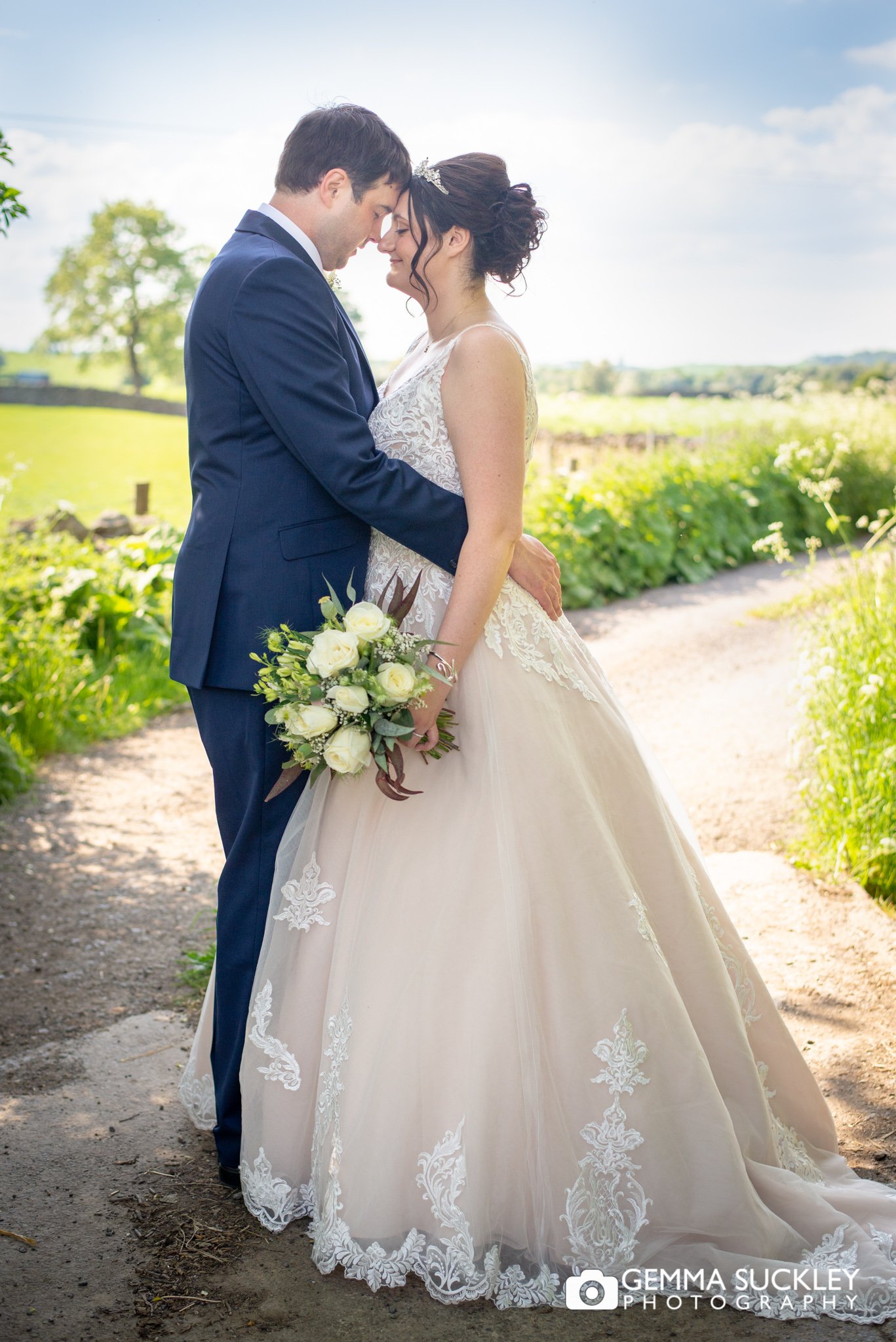 newly weds cuddling on a country lane in north yorkshire