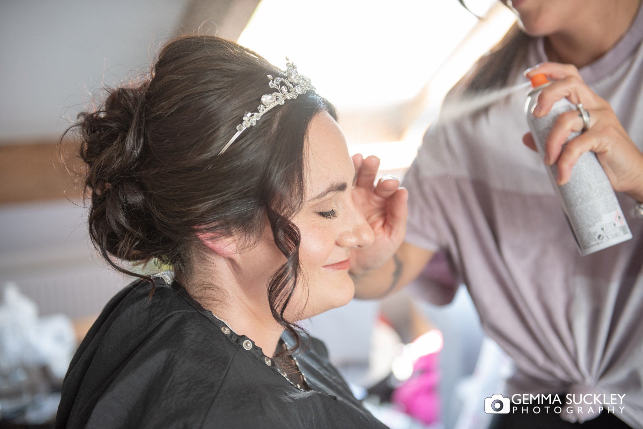 hairspray being sprayed on the brides hair