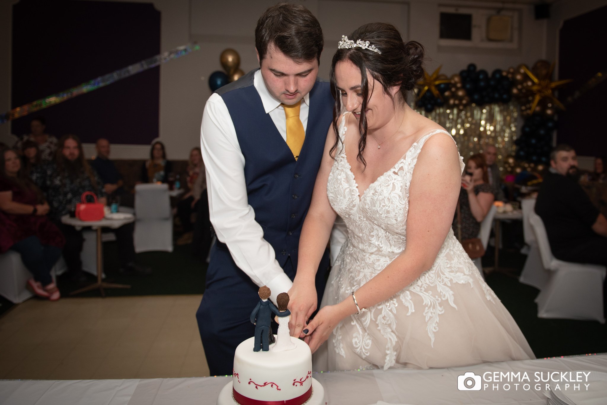 the bride and groom cutting their wedding cake