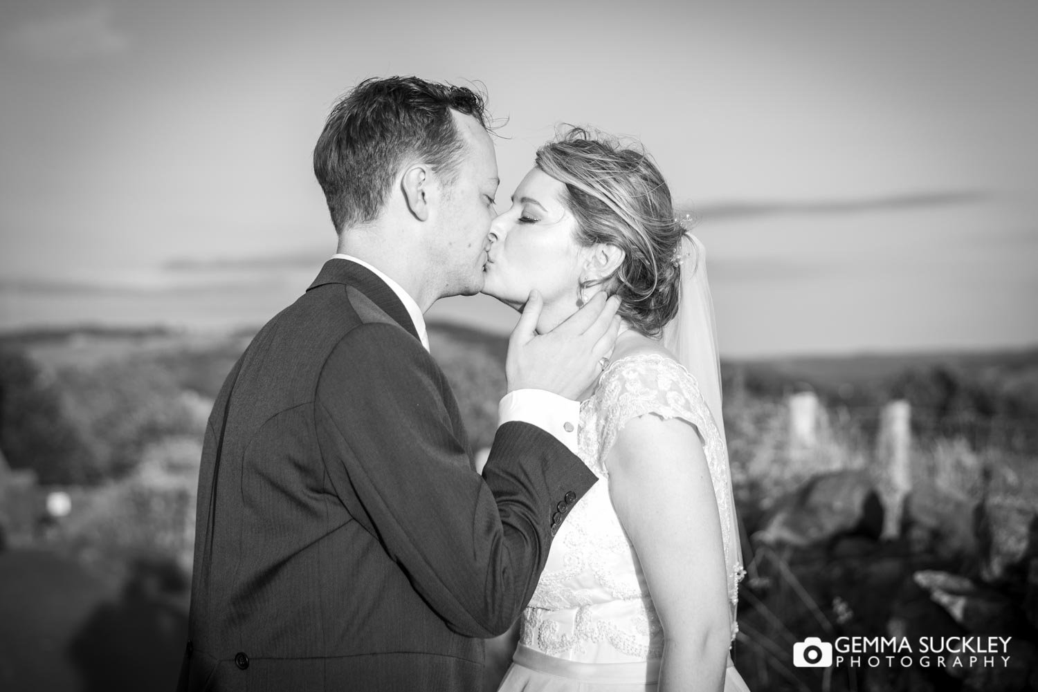a bride and groom kissing in the sunshine