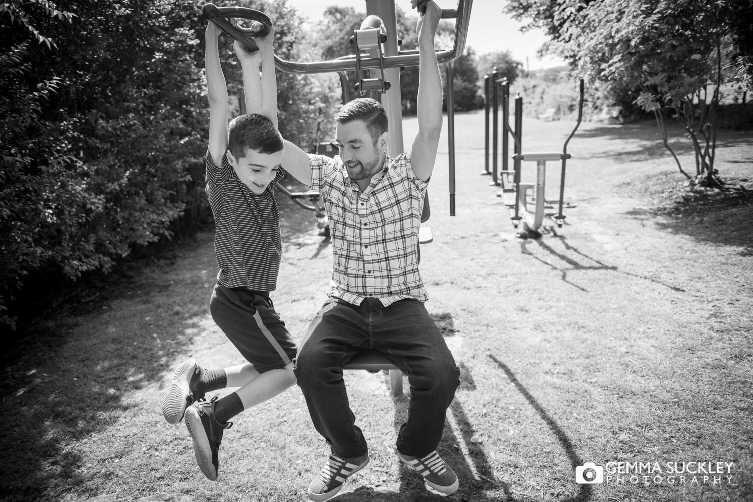 a father and son playing on the exercise playground in lothersdale park