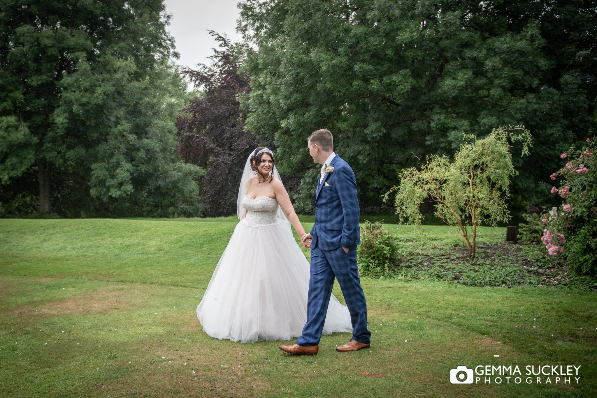 bride and groom walking in the garden at hollins hall hotel