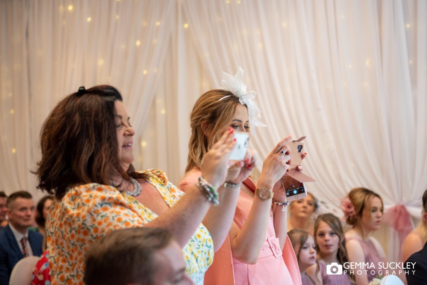 wedding guests taking phot of of the bride and groom at hollins hall