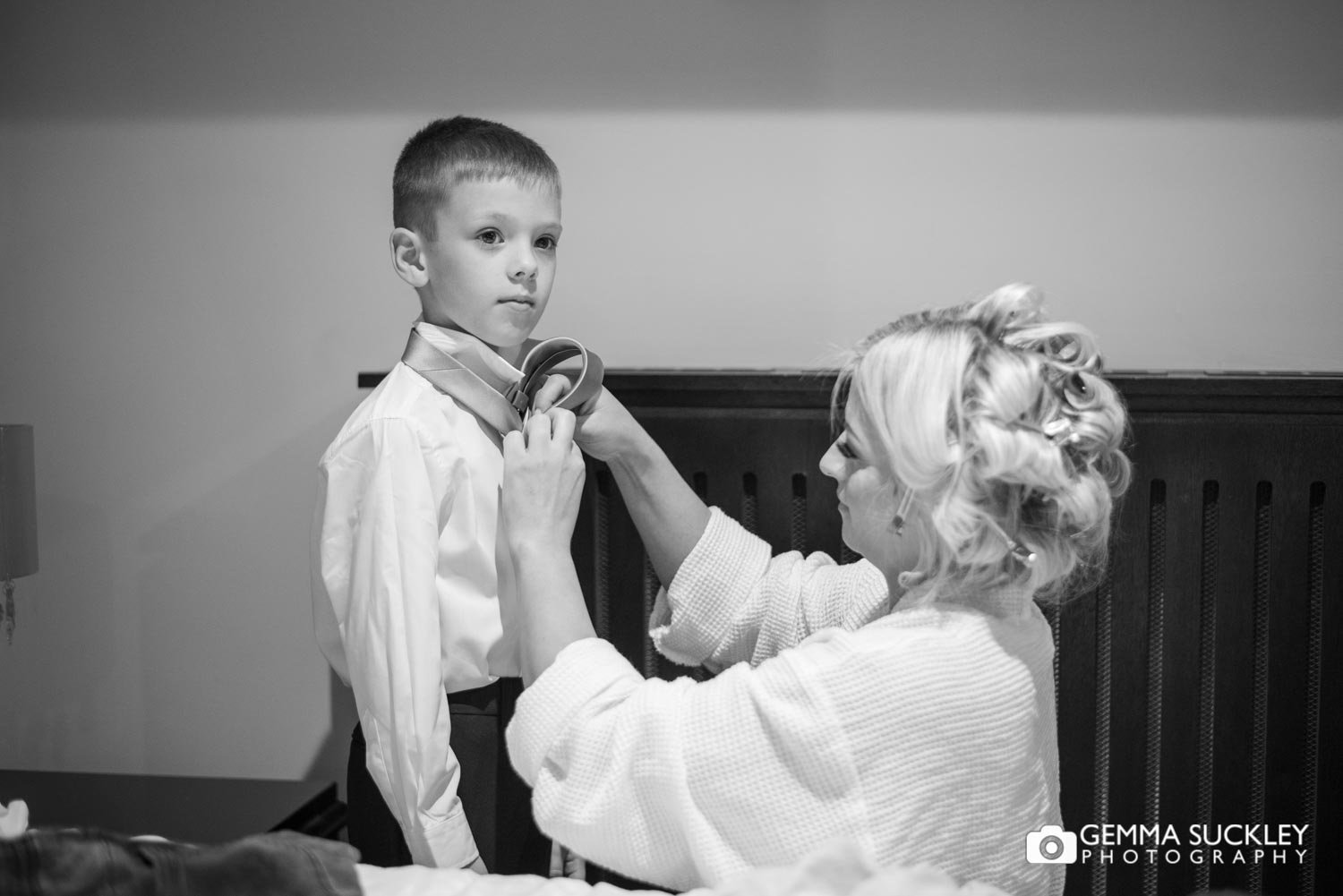 the bride putting on the pageboys tie