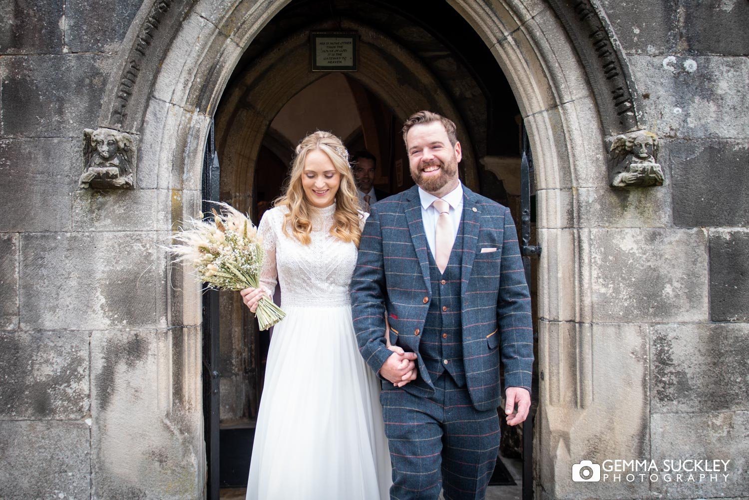 just married bride and groom smiling as they exit linton church