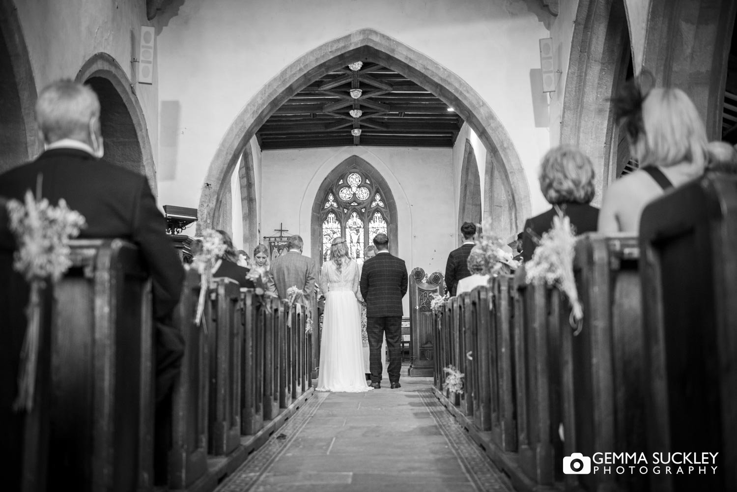 bride and groom standing before the priest at their wedding