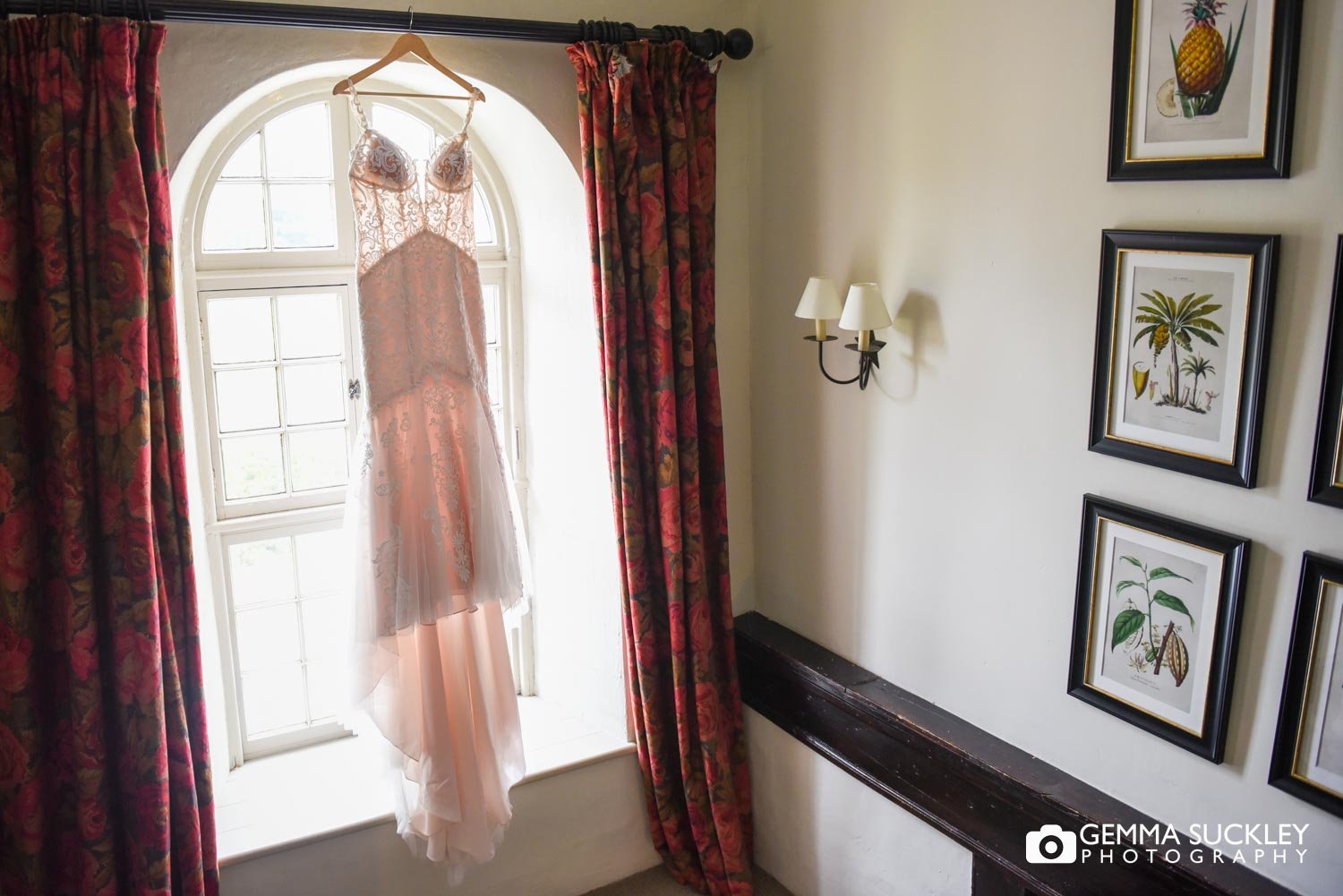 wedding dress hung in in front of grand window at swinton estate house