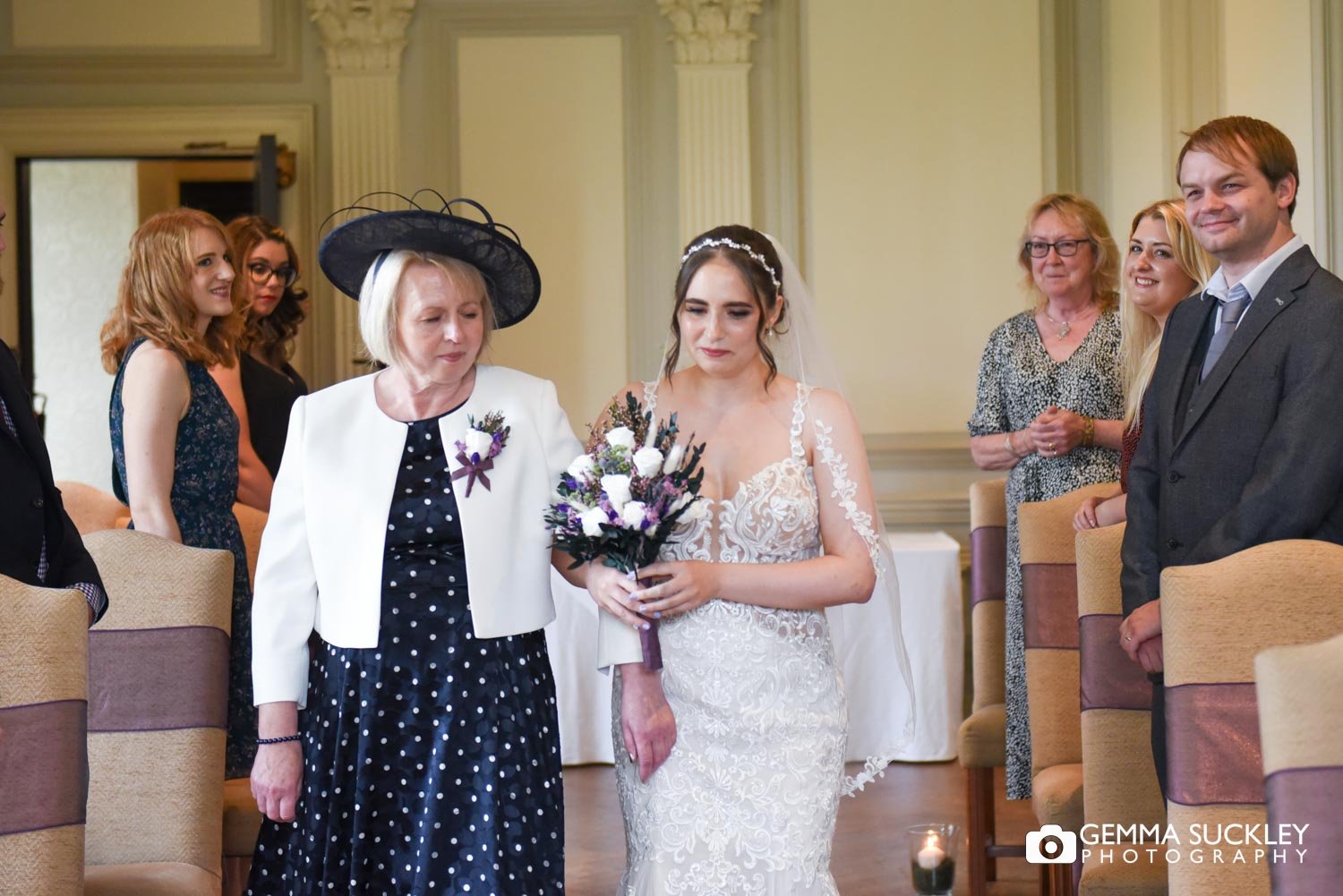 bride and her mum walking down the aisle at swinton park 