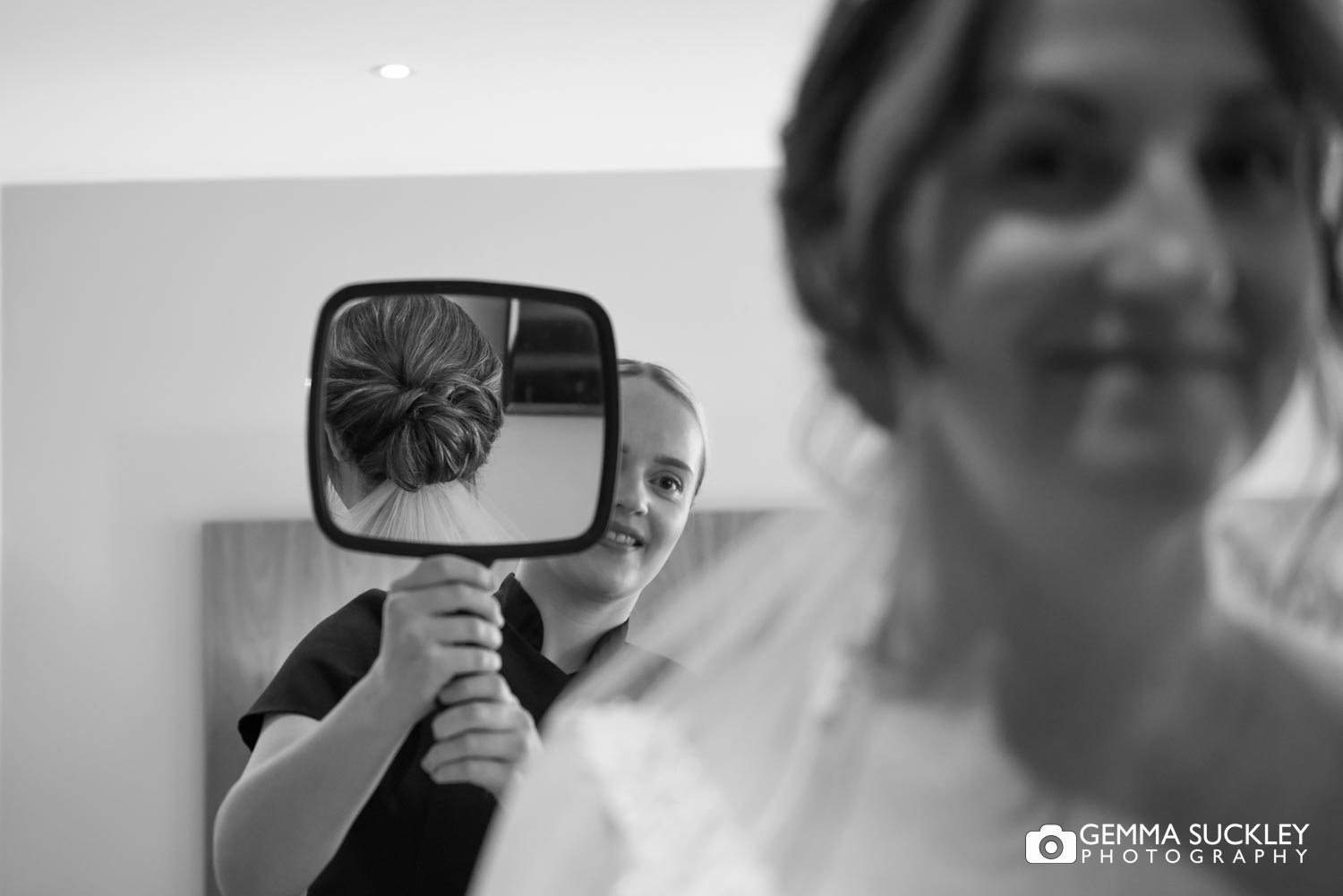 a bride looking in the mirror at her hair