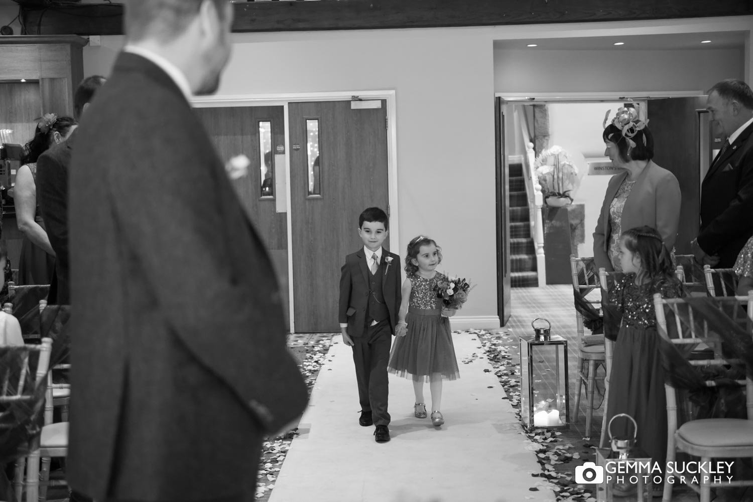 pageboy and flower girl walking down the alise at the coniston hotel
