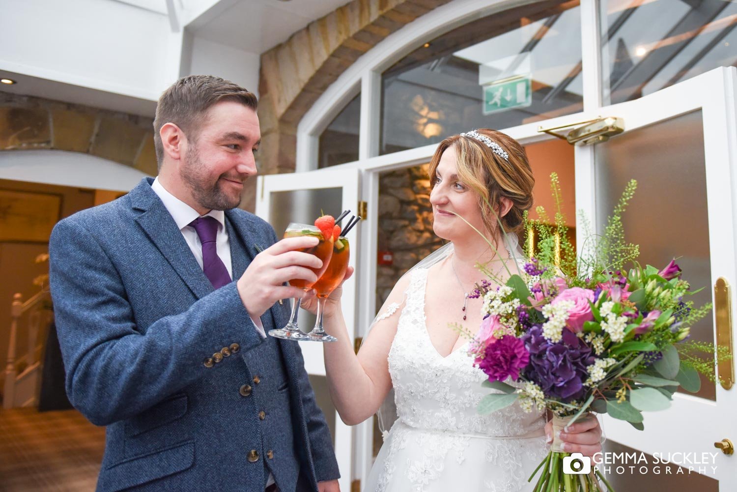 the bride and groom clinking pims glasses