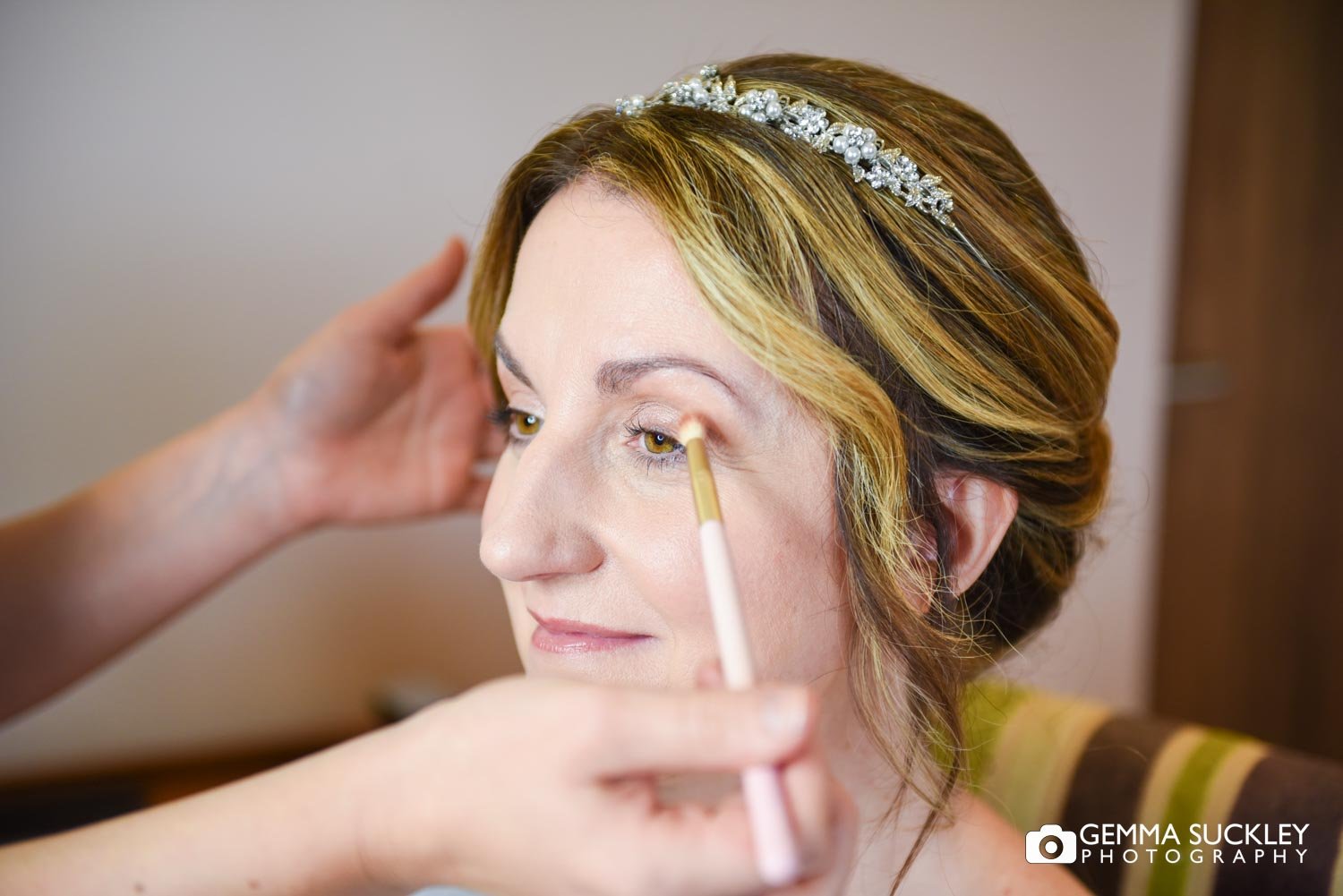 make up artist applying makeup to the bride