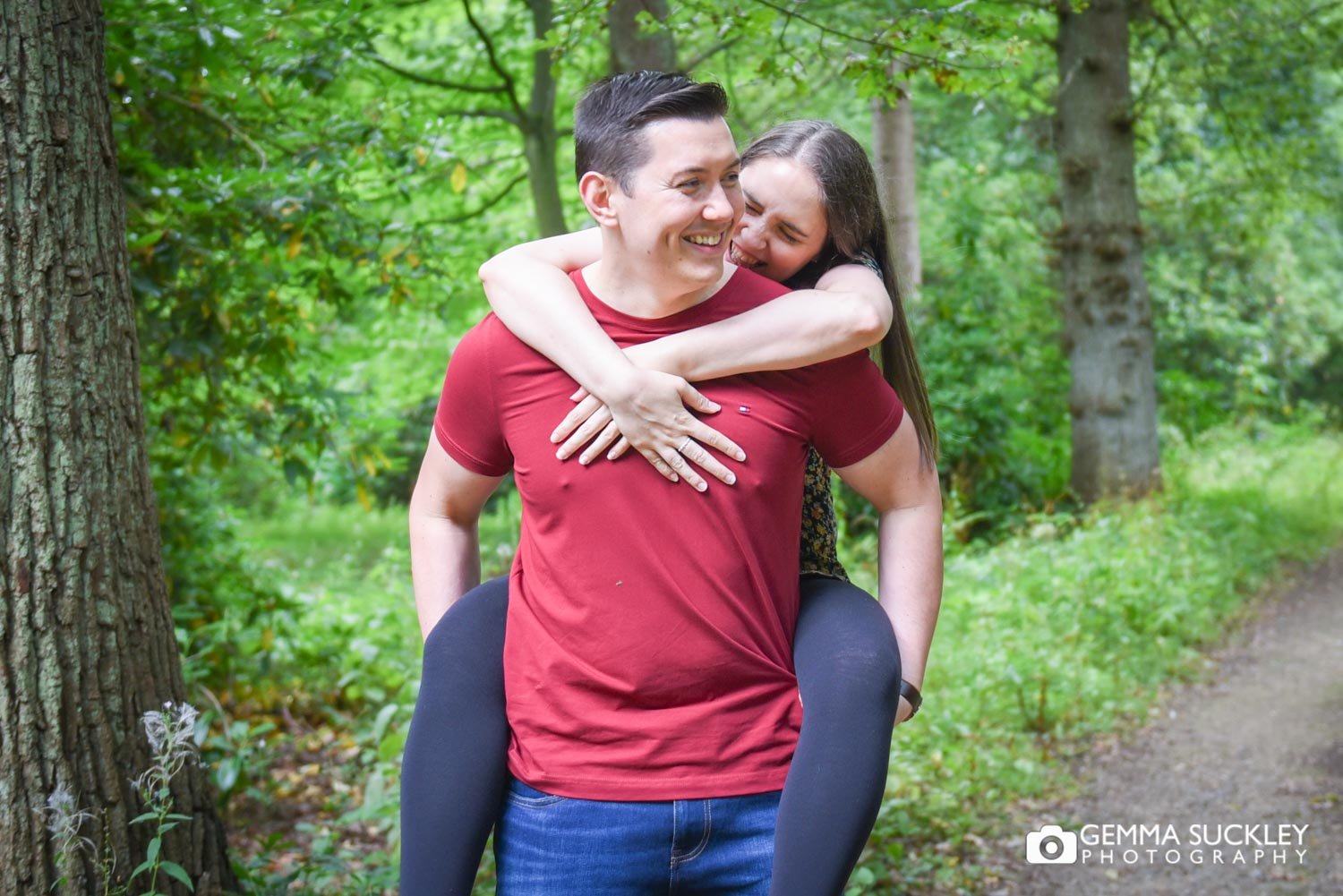 engaged couple laughing as he piggybacks her