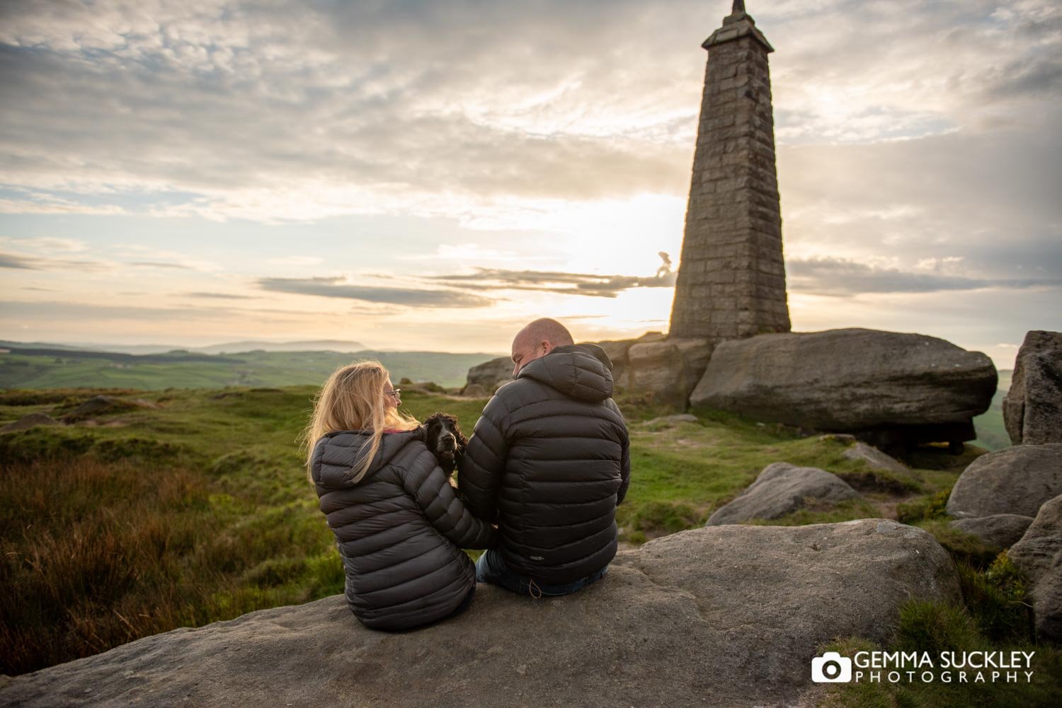 an engaged couple and their dog at sunset on cowling pinnacle