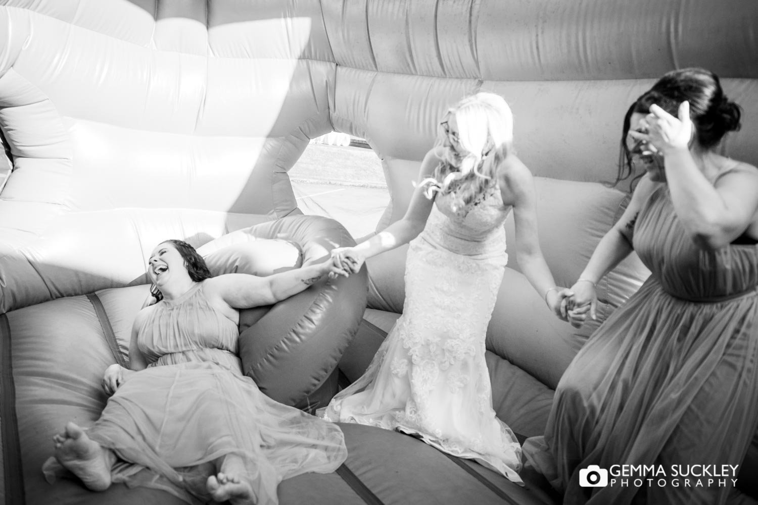 a bride and bridesmaids on a bouncing castle