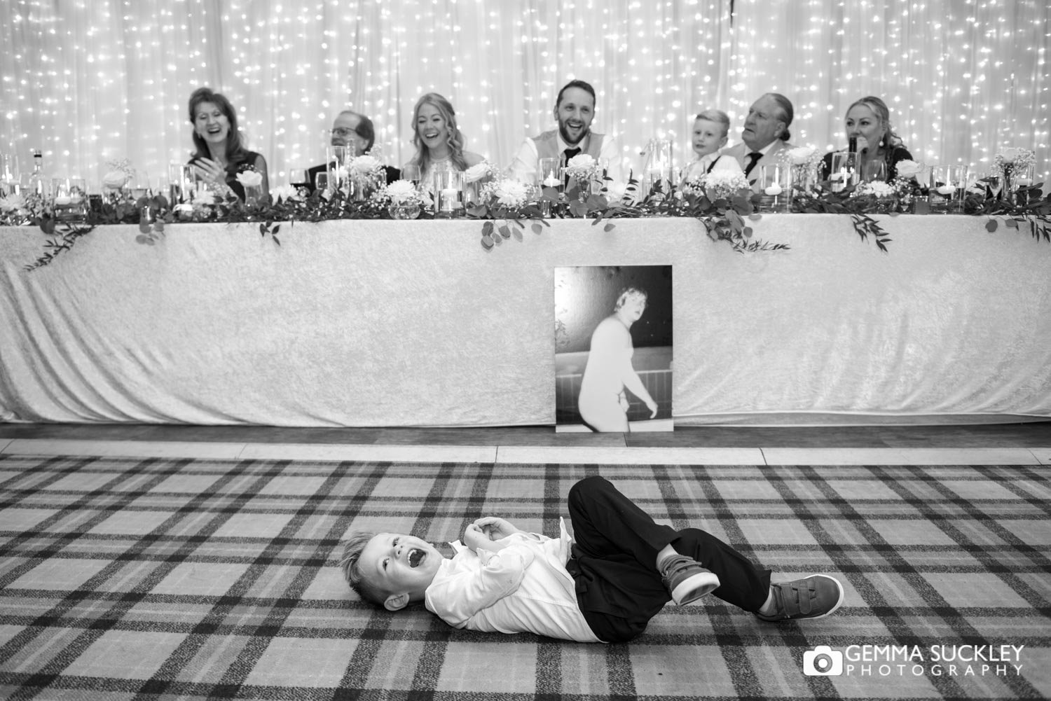 pageboy laying on the floor laughing during speeches at coniston hotel