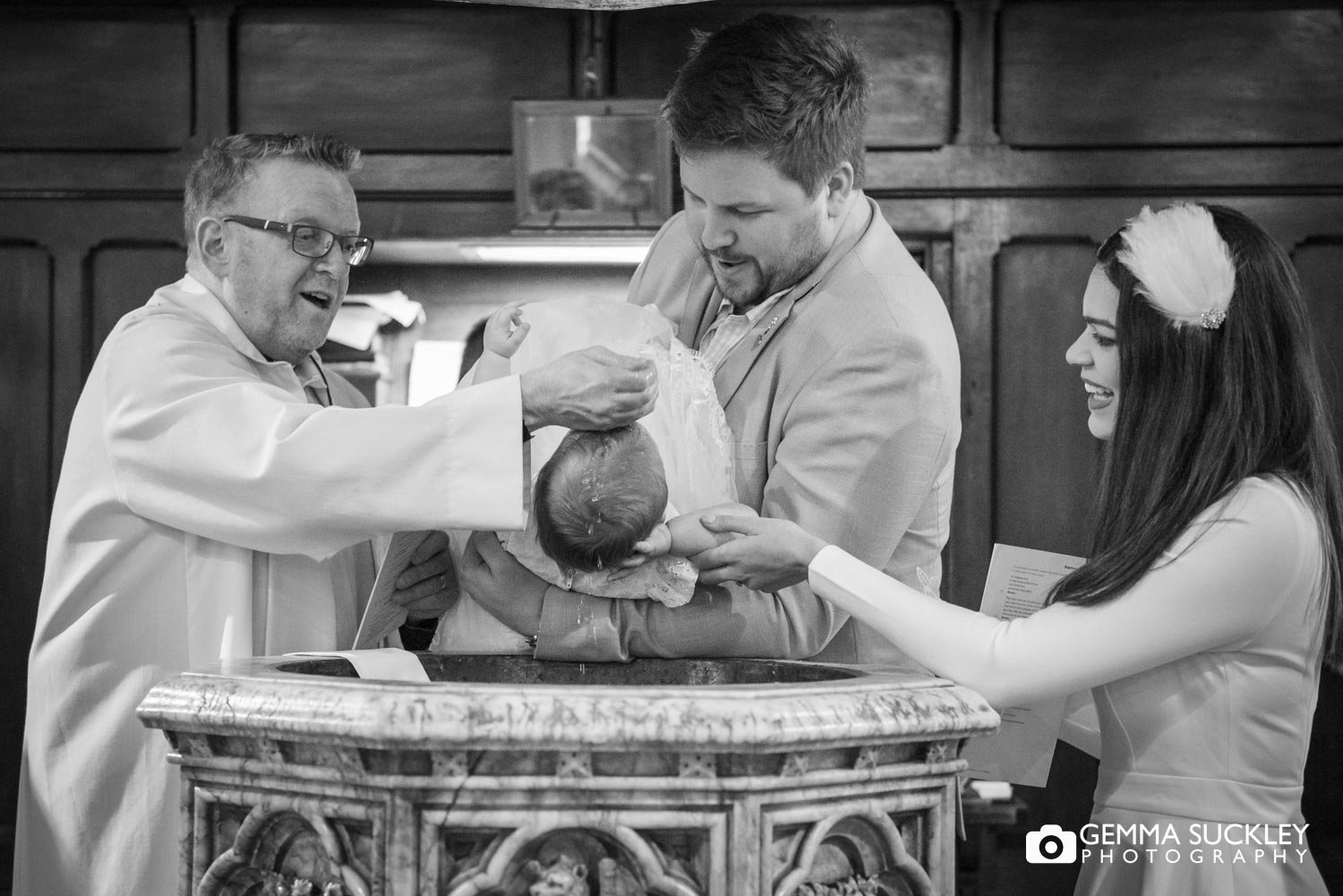a priest wetting the babys head at a christening in gargrave