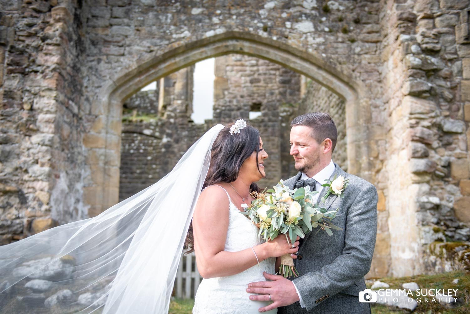 bride and groom smiling in front of barden tower