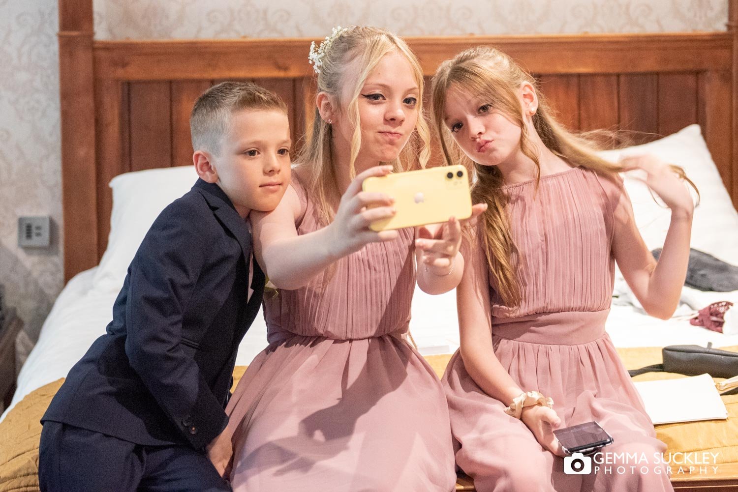 two bridemaids and a pageboy taking a selfie