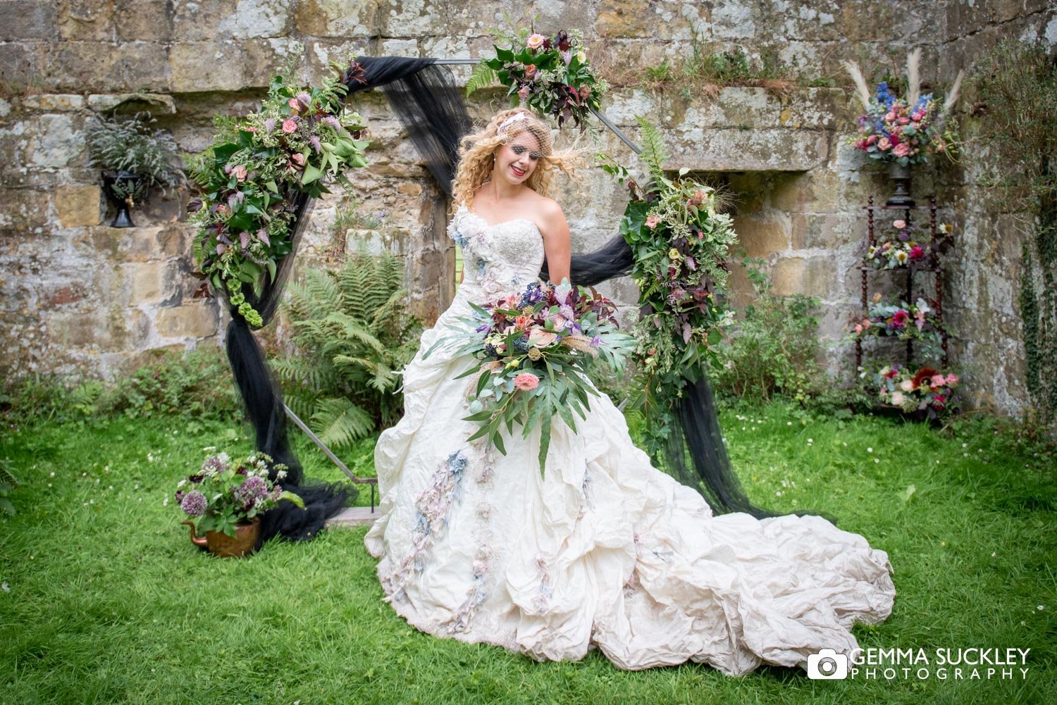 a bride in front of a flower ache at jervaulx abbey