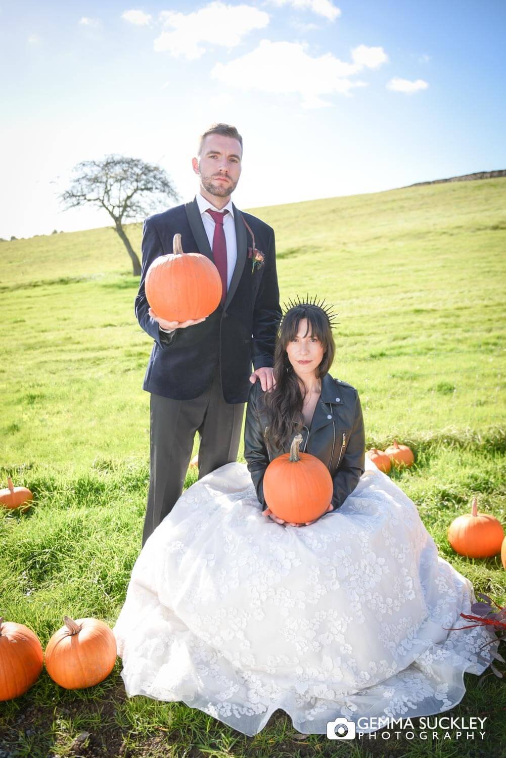 a bride and groom holding pumpkins at Thornton hall halloween wedding