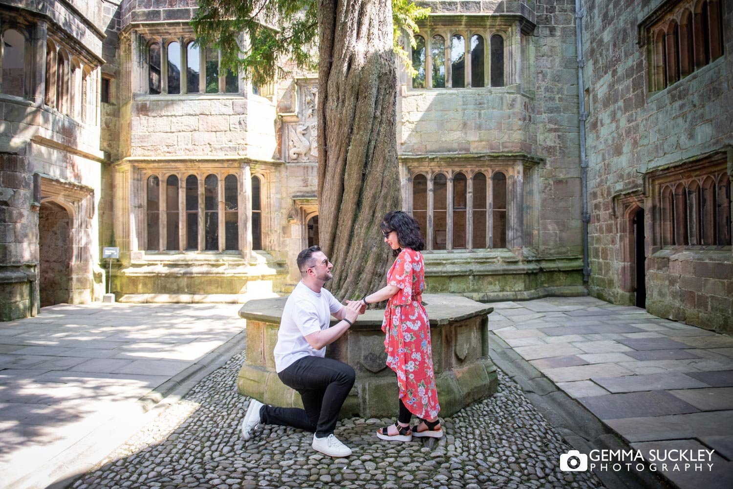 a man down on one knee proposing at skipton castle