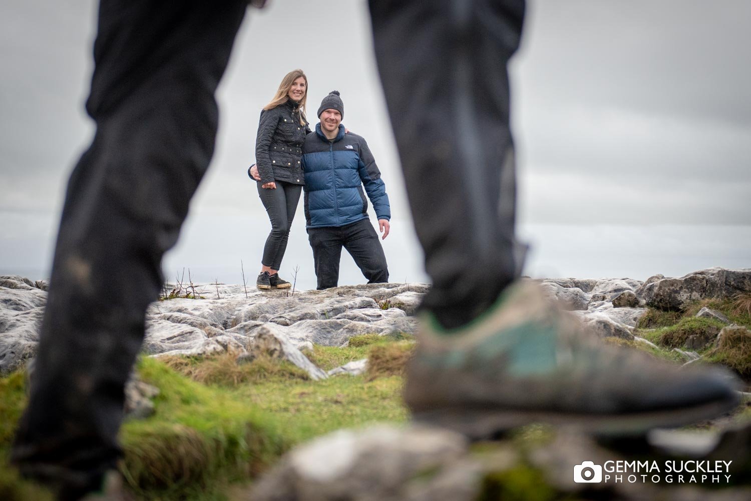 engaged couple smiling at the camera as a walking passed on malham cove