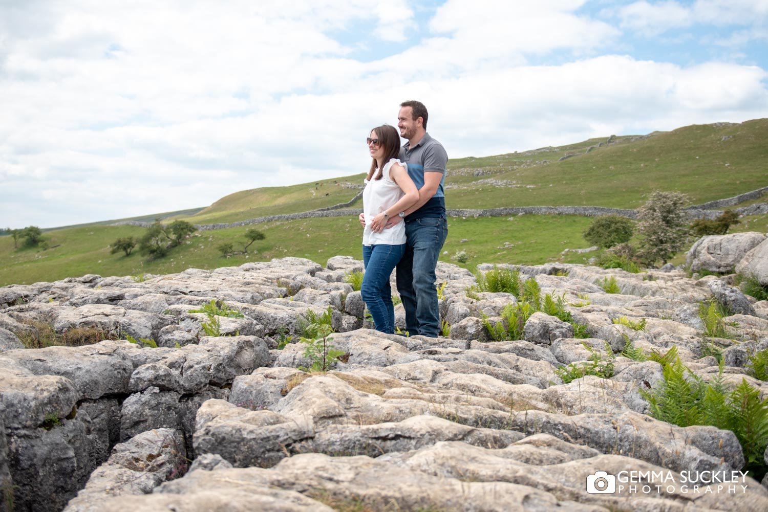 a couple standing at the top of malham cove