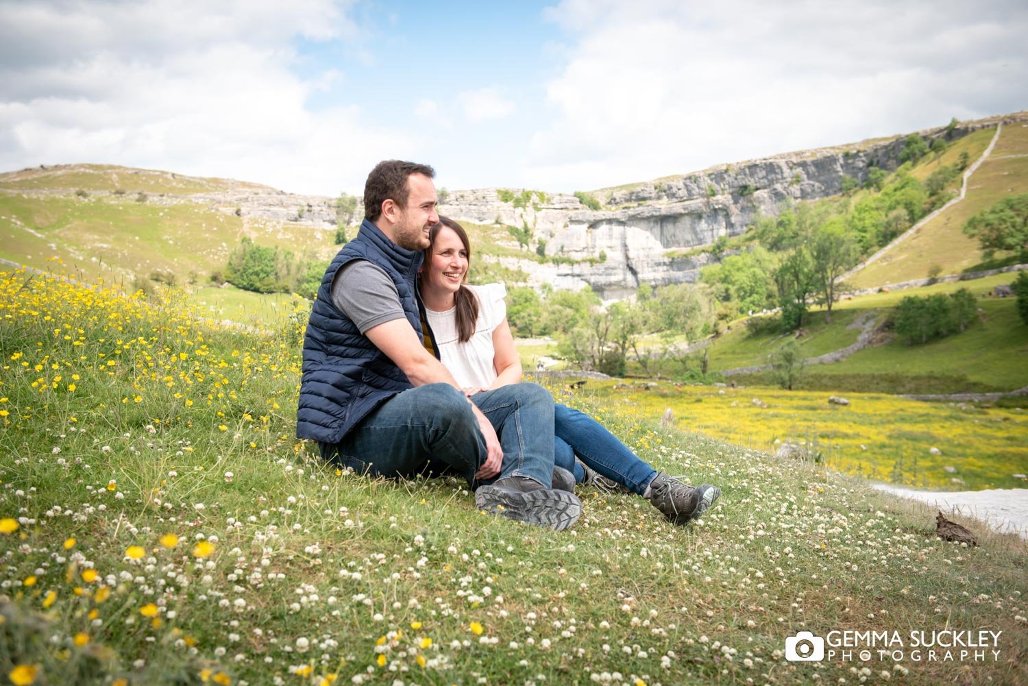 engaged couple sitting in the daisy's near malham cove