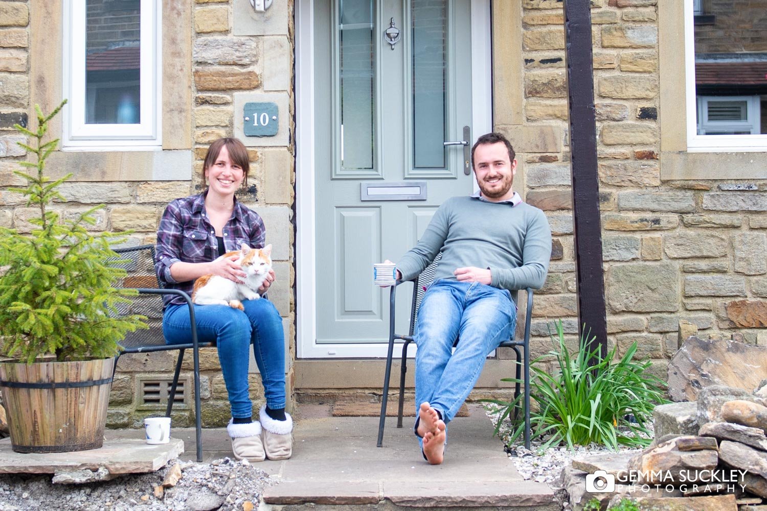 a couple sat on their doorstep with their cat