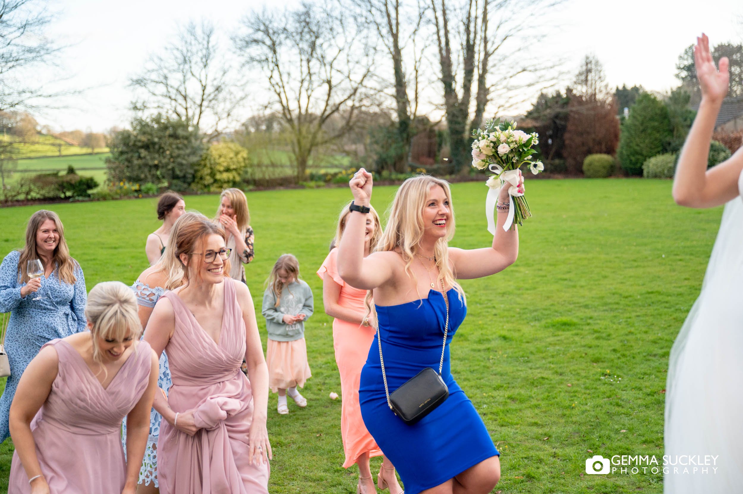 a lady looking happy after catching the tossed bouquet
