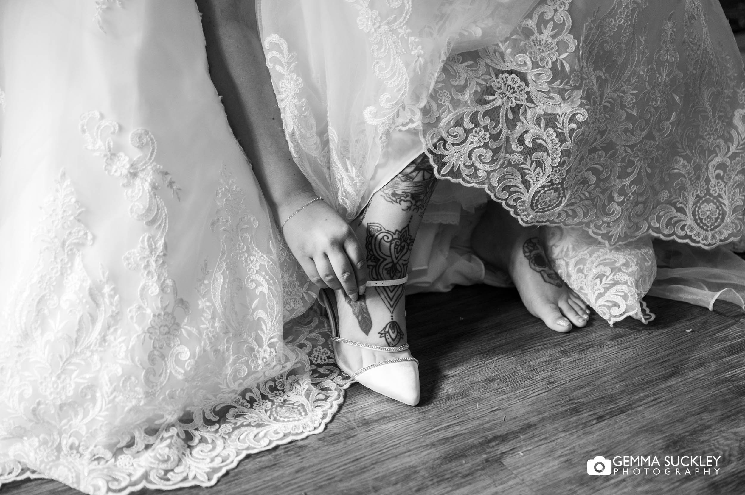 bride putting on her bridal shoes