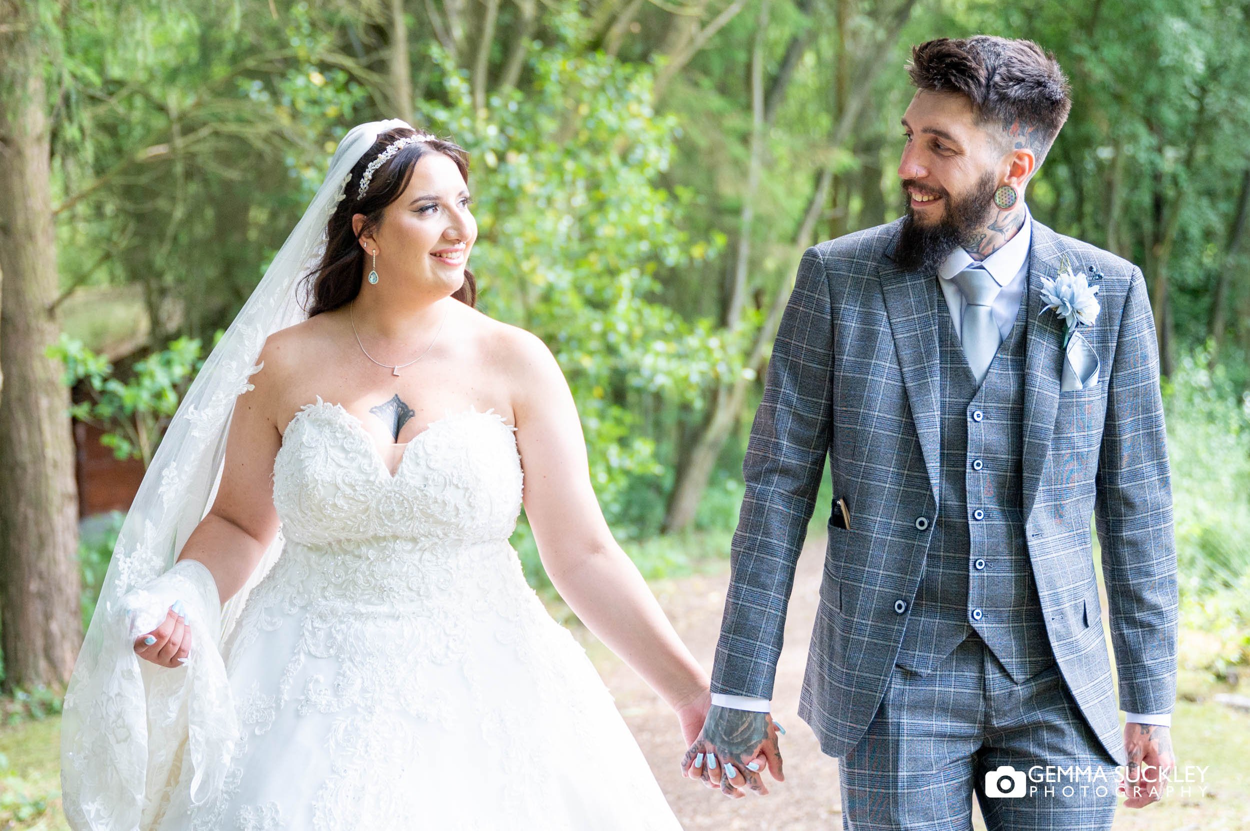 tattooed bride and groom walking through the woodland at otley chevin country park hotel