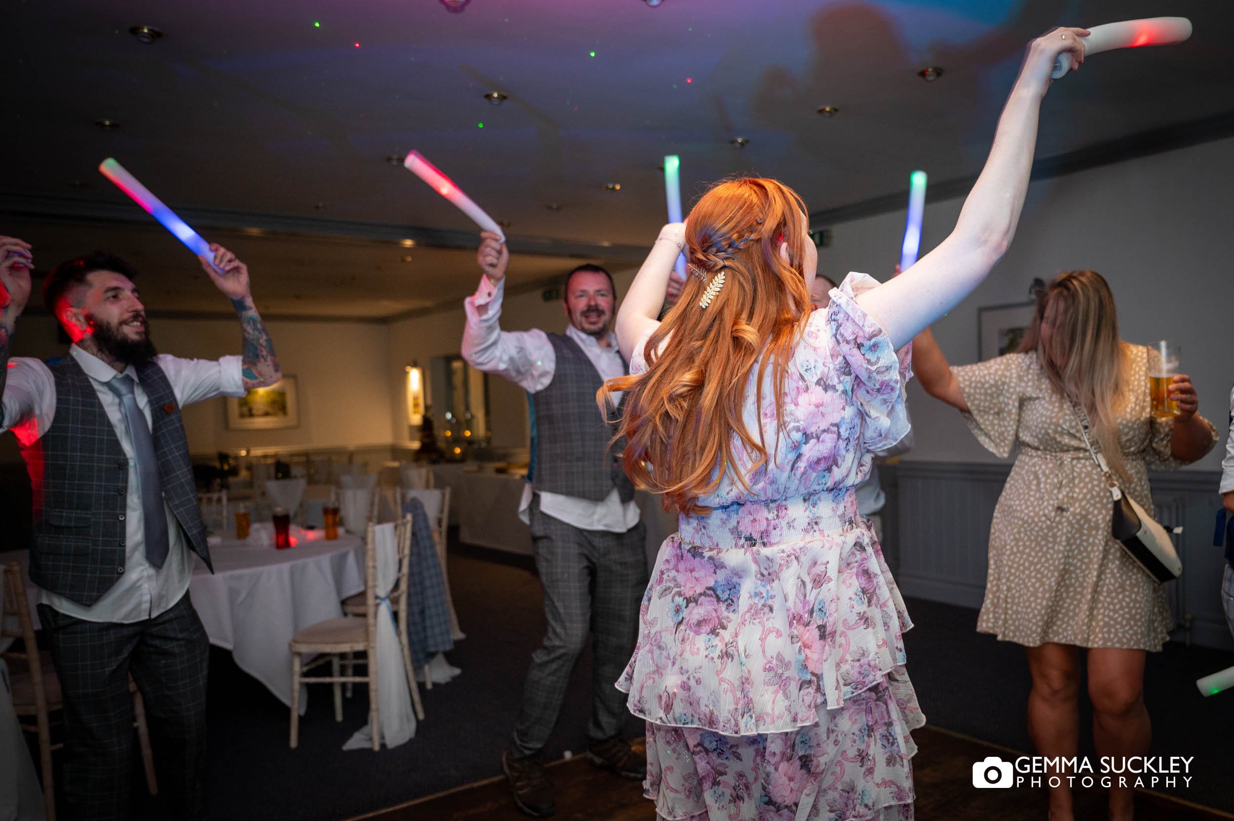 wedding guests with glow stick at the wedding reception in otley