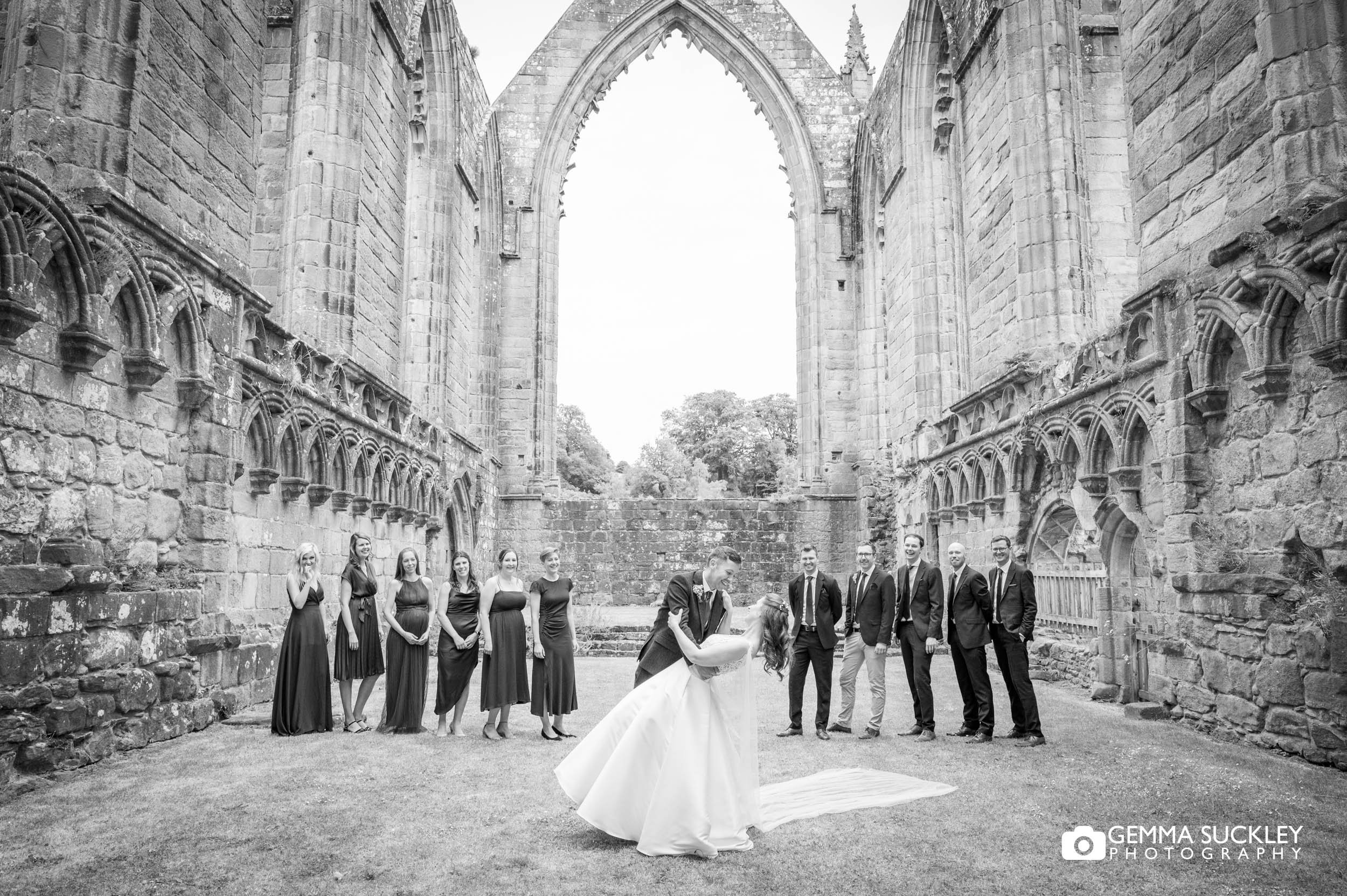 the groom dipping this bride over at bolton abbey priory ruins