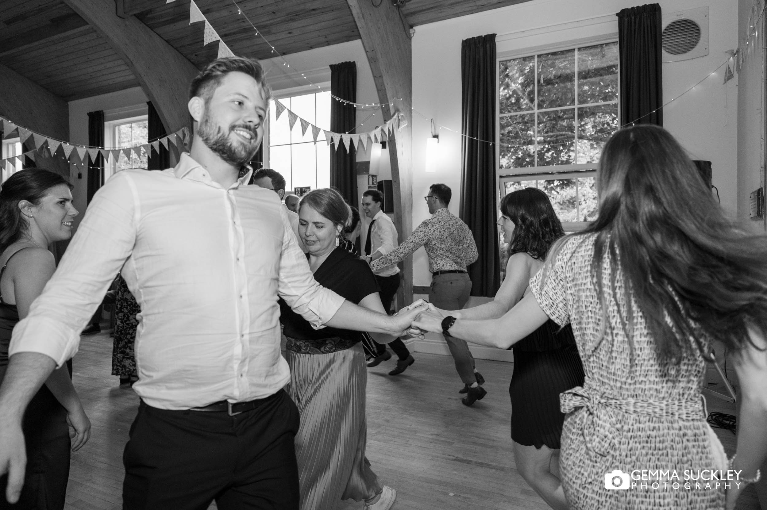 wedding guests doing the ceilidh at bolton abbey village hall