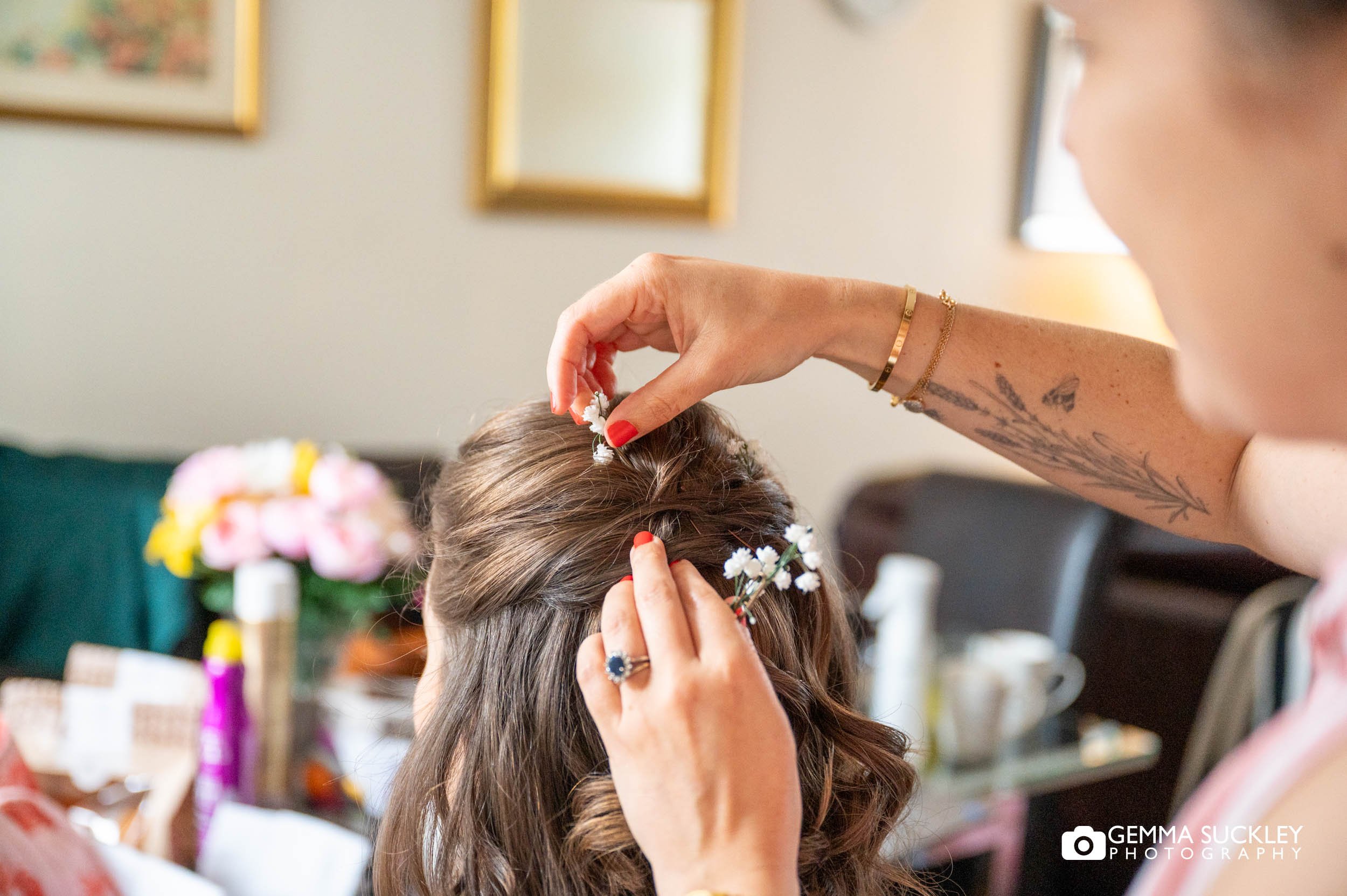 hairdresser adding flowers to the brides hair