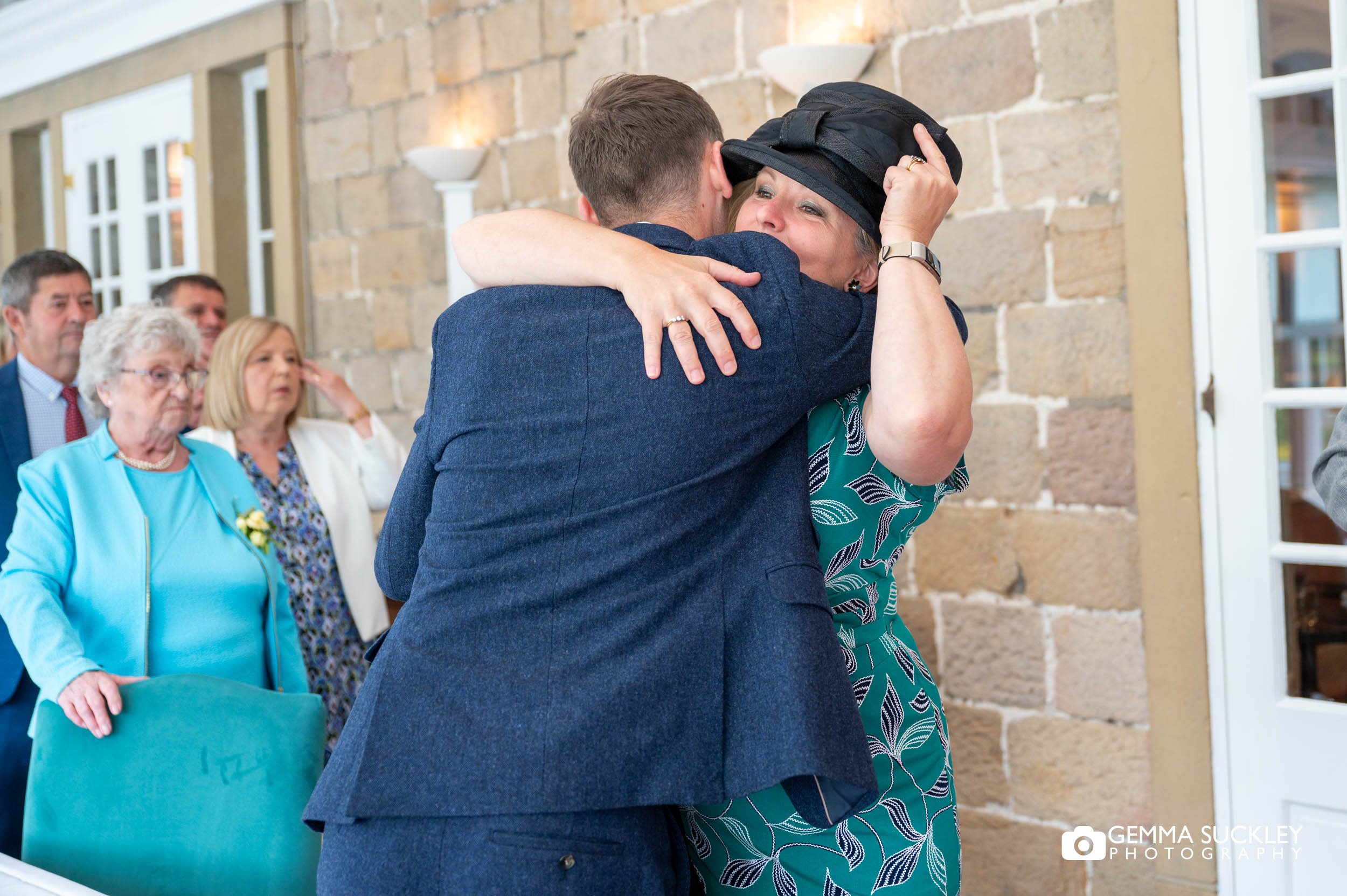 the groom hugging a wedding guest