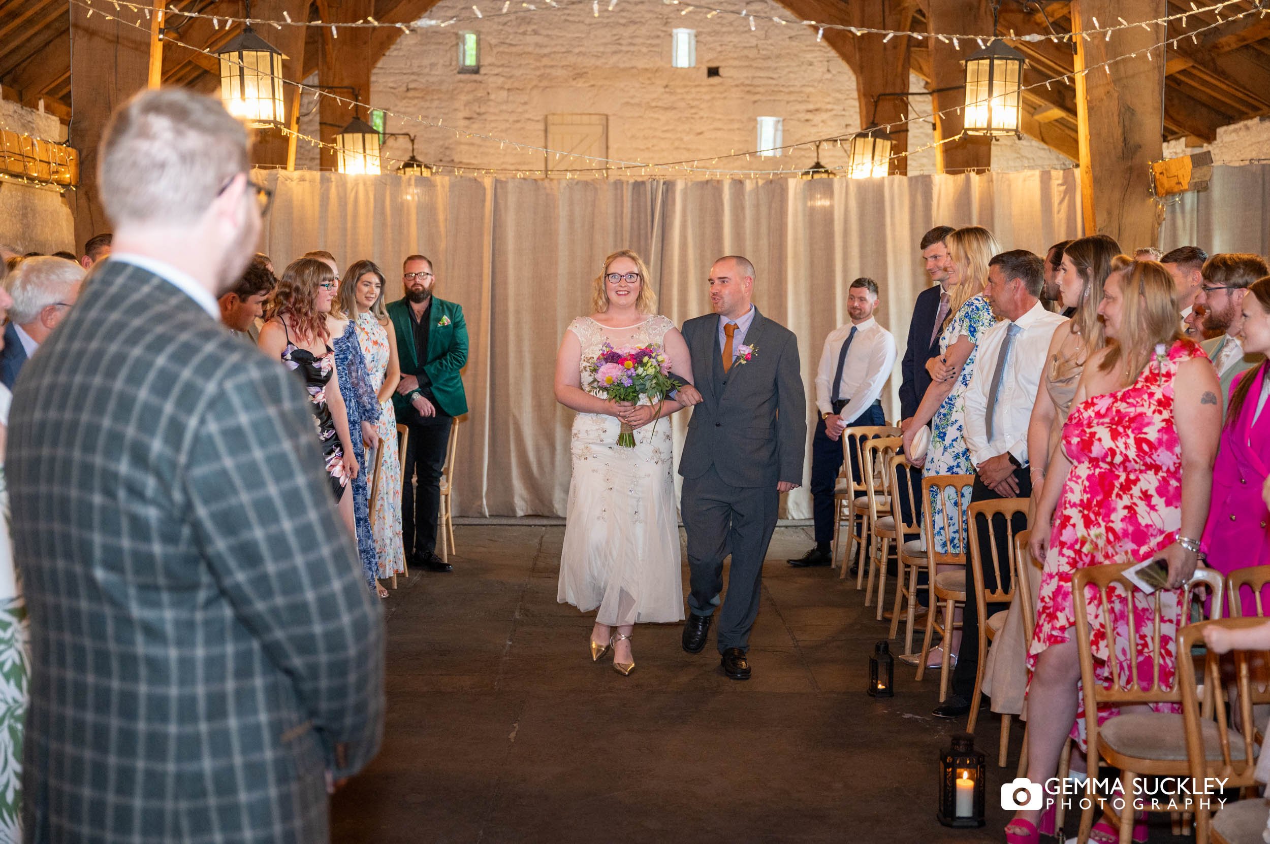 groom watching his bride walk up the aisle 