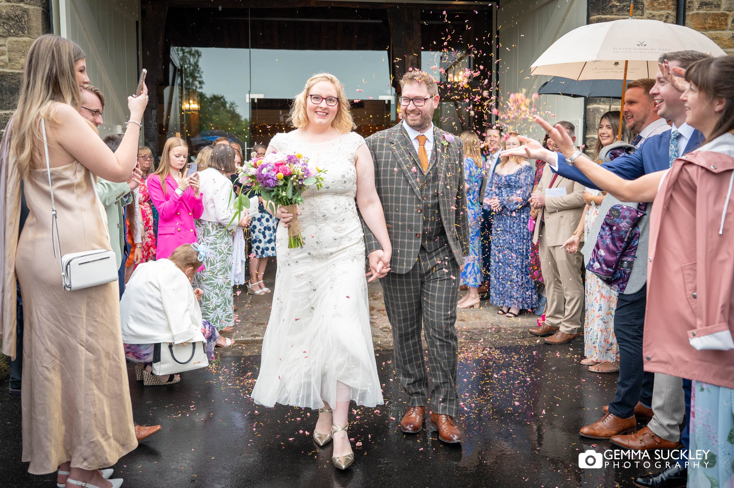 wedding guests throwing confetti as the bride and groom exit east riddlesden hall