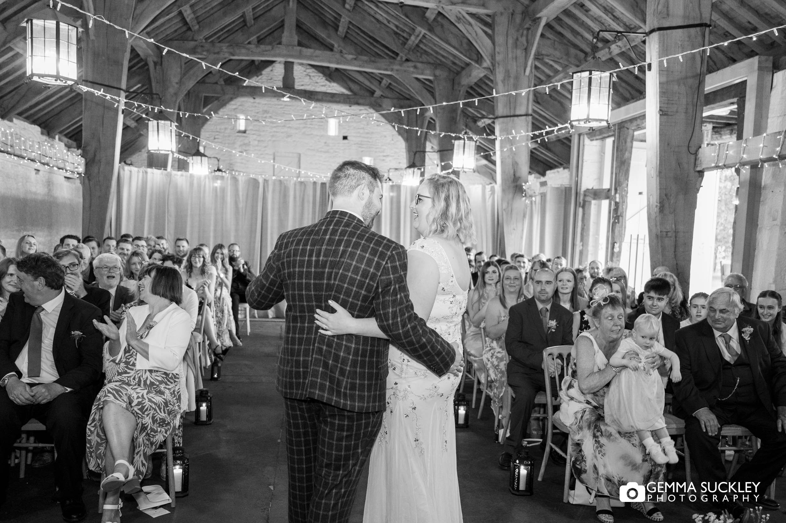 wedding guest clapping as bride and groom finish the kiss