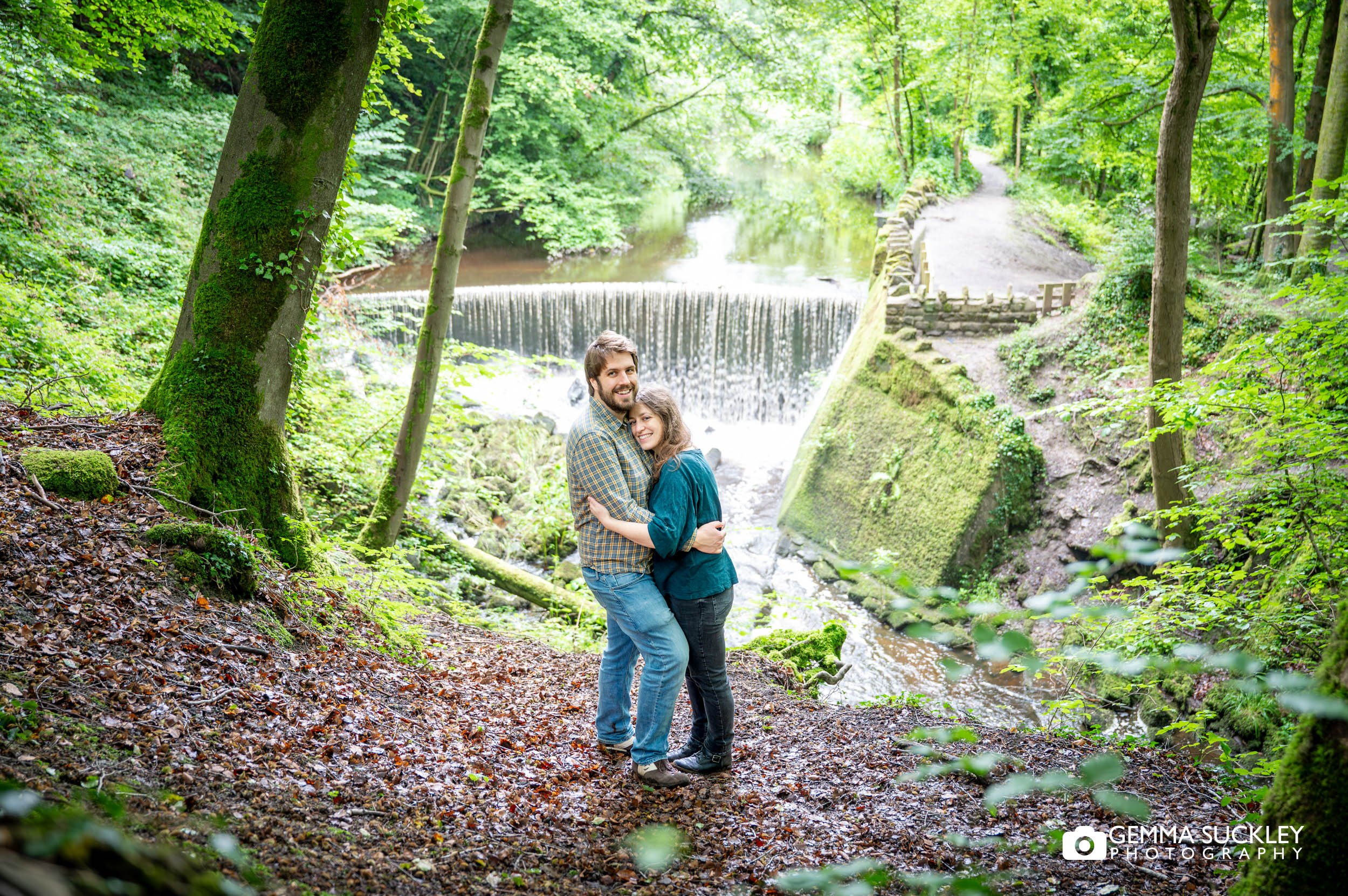 engaged couple in front of the waterfall in skipton wood