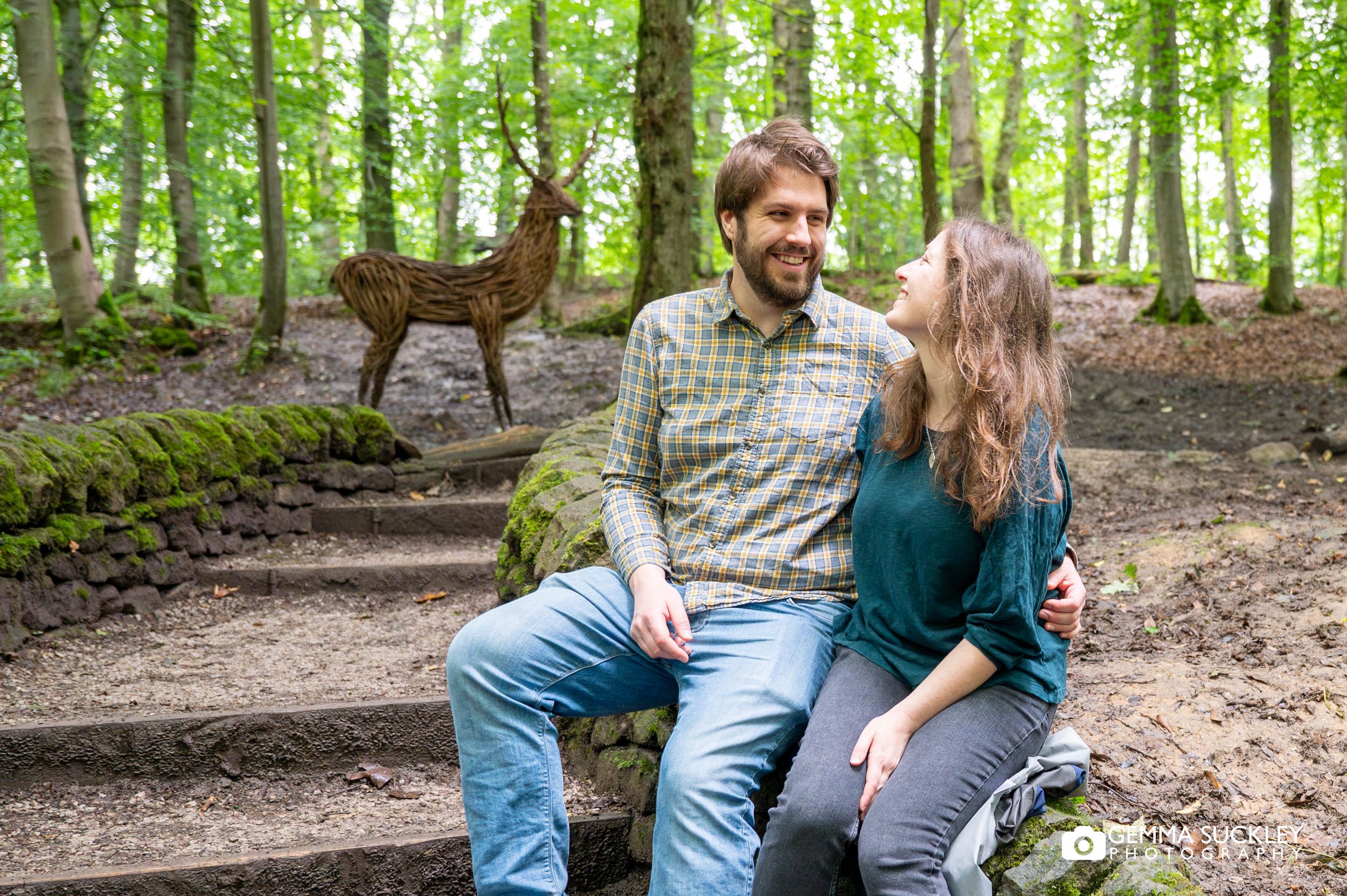 engaged couple sitting in the bridge in skipton woods