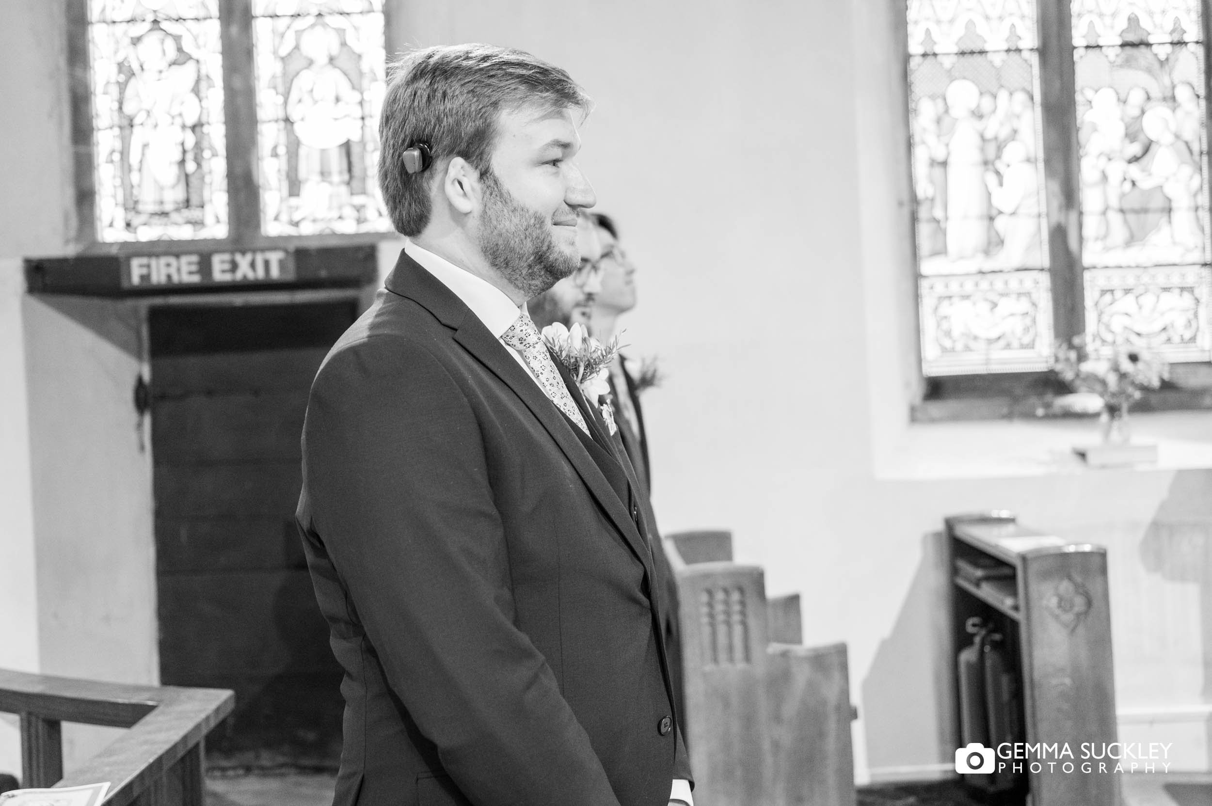 groom waiting for his bride to walk down the church aisle